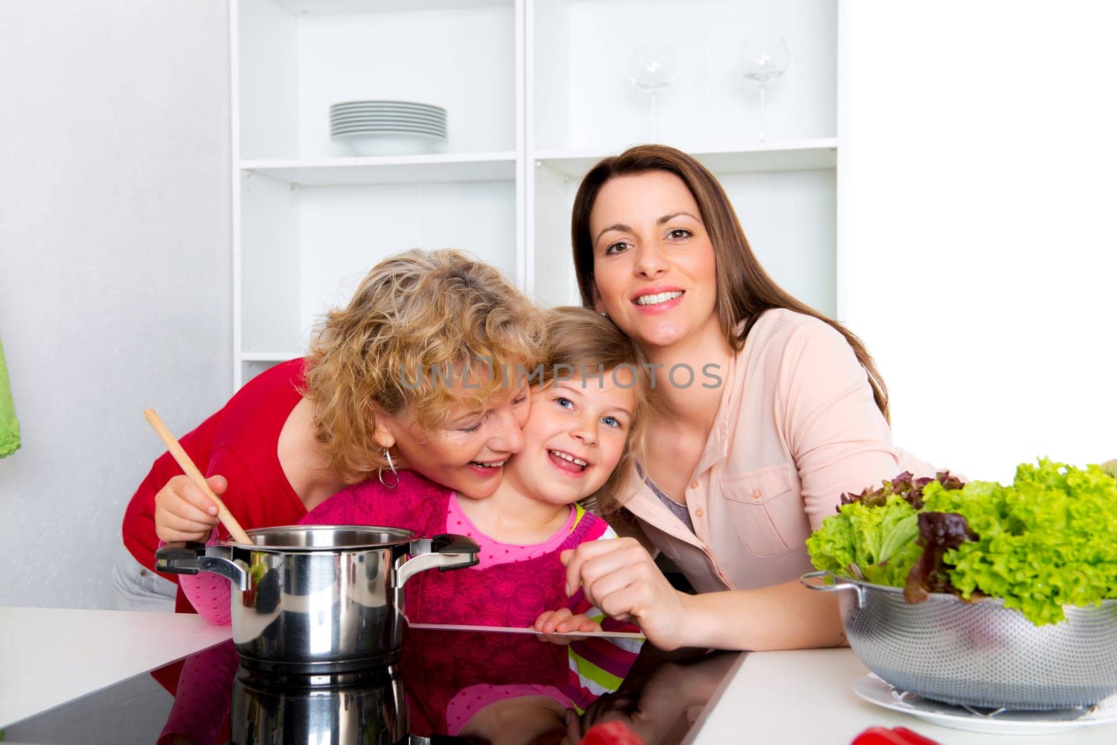 woman with daughter and grandchild together cooking together in the kitchen