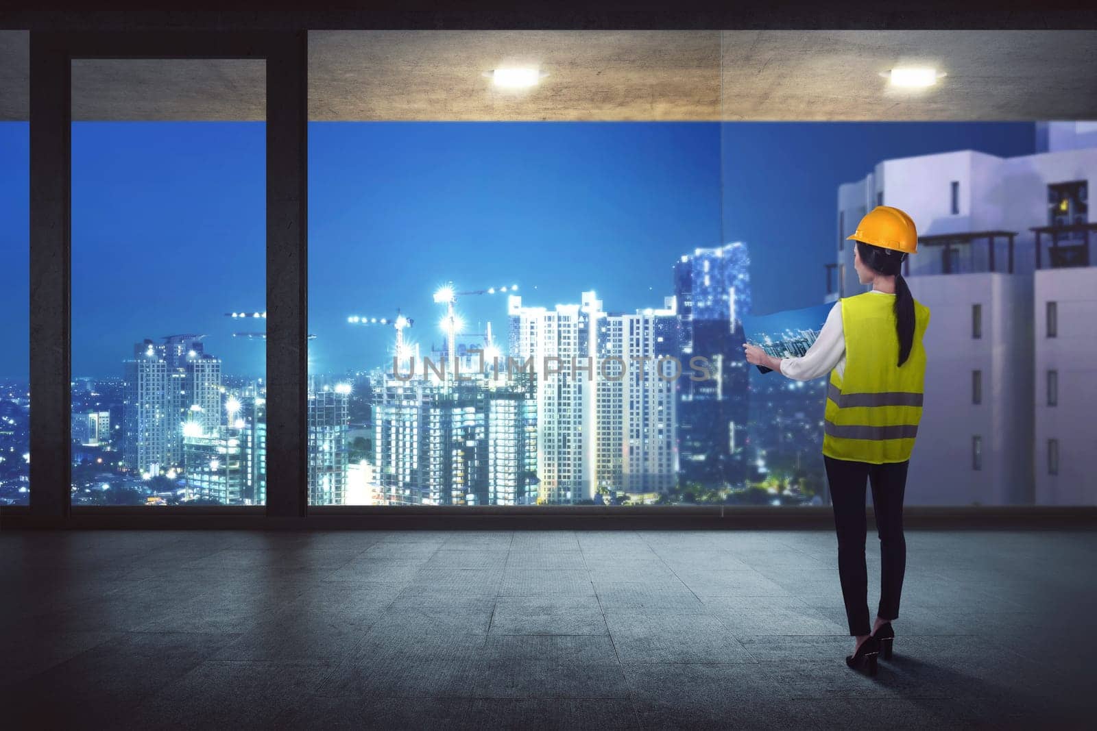 Rear View of asian construction woman looking the construction on the city from the office