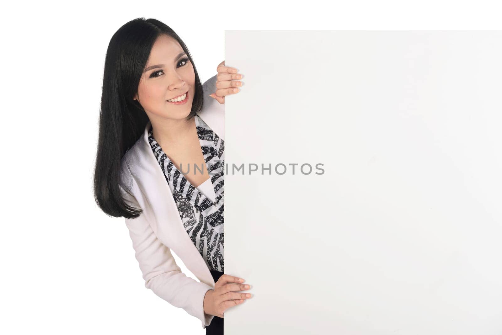 Beautiful asian business woman standing behind blank sign board with copyspace isolated over white background