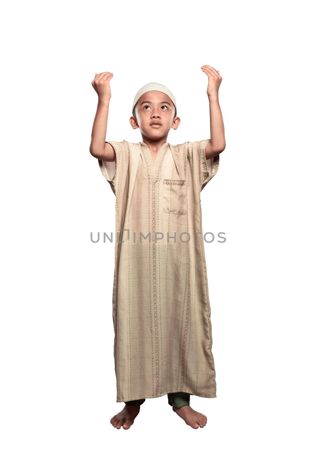 Portrait of asian muslim kid with cap praying isolated over white background