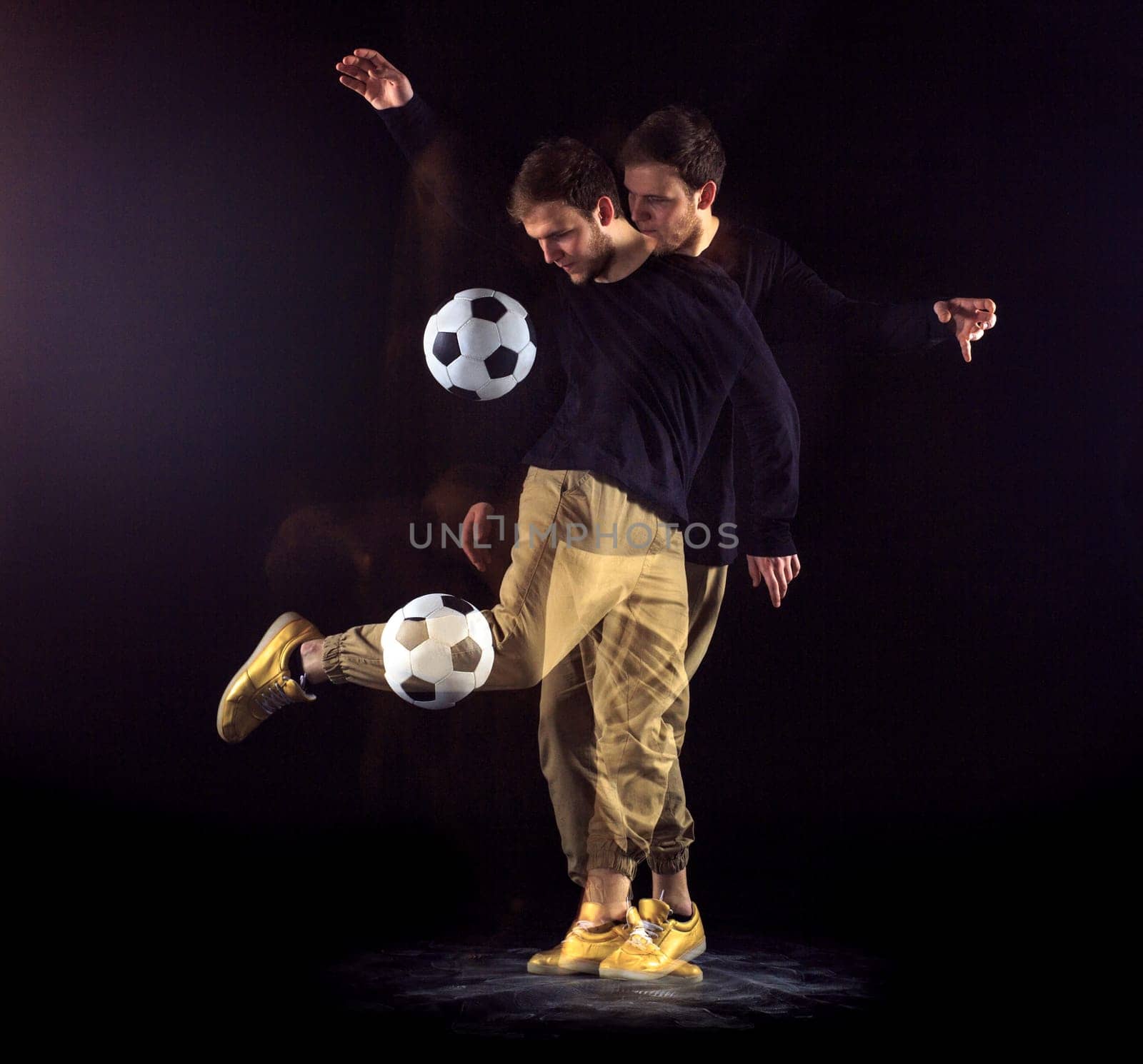 A portrait of a fan with ball on gray studio background. Freestile concept. Stroboscope shooting technique