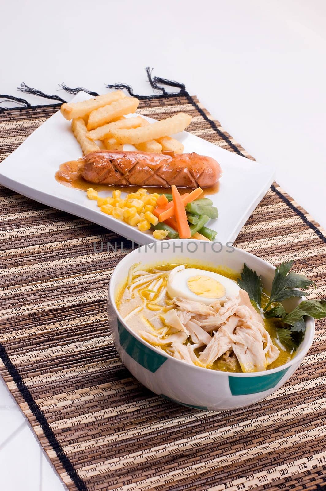 Indonesian traditional chicken soup and sausage served with french fries