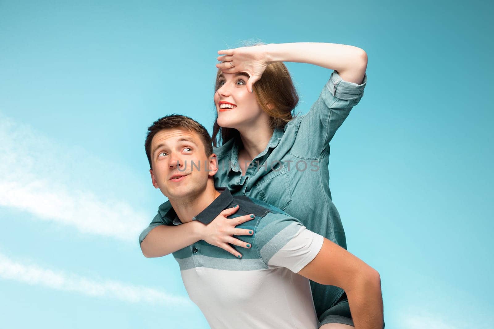 Young love Couple smiling under blue sky and looking away