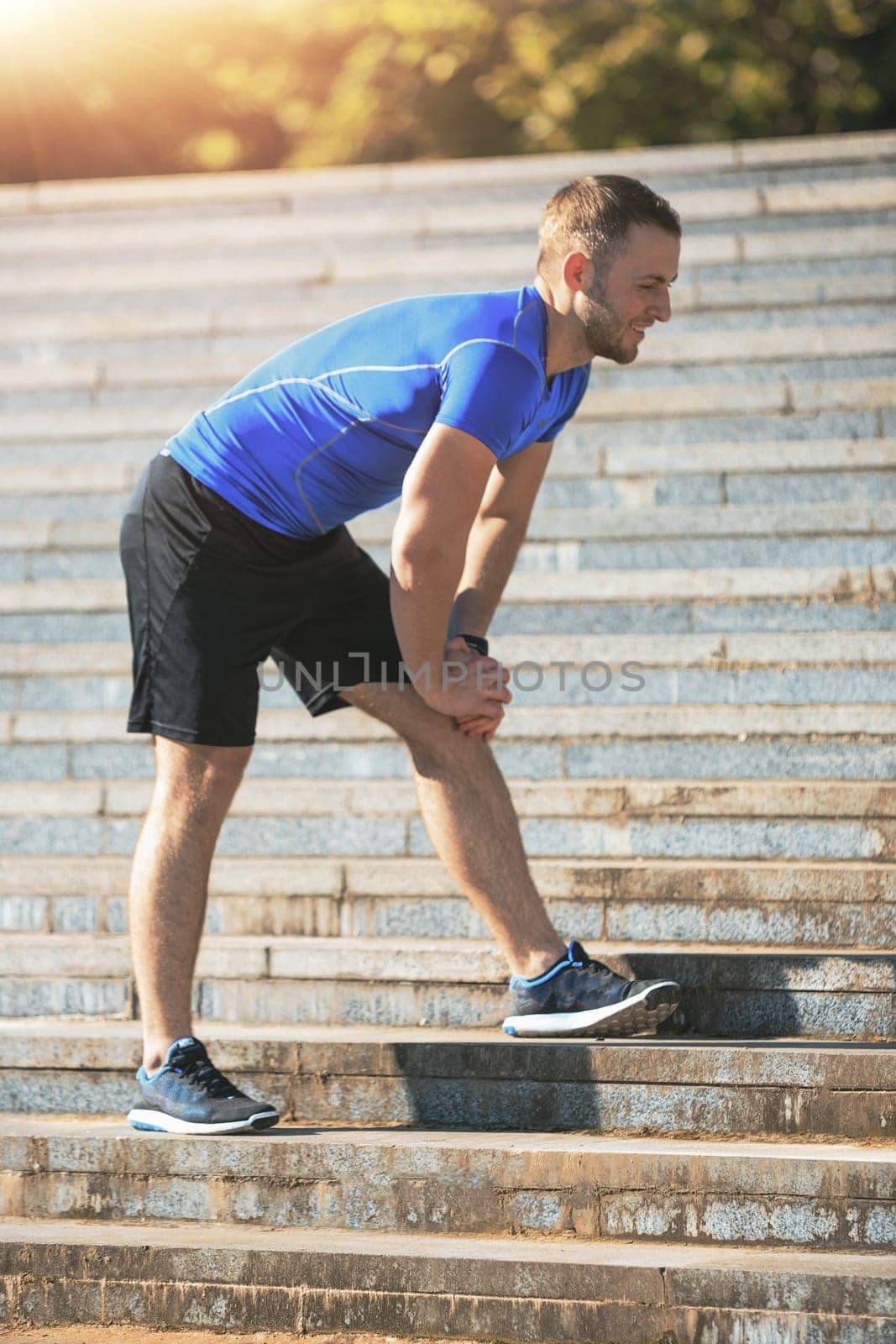Fit fitness man doing exercises outdoors at park. The man doing exercises. The male sports model jumping outdoor in summer.