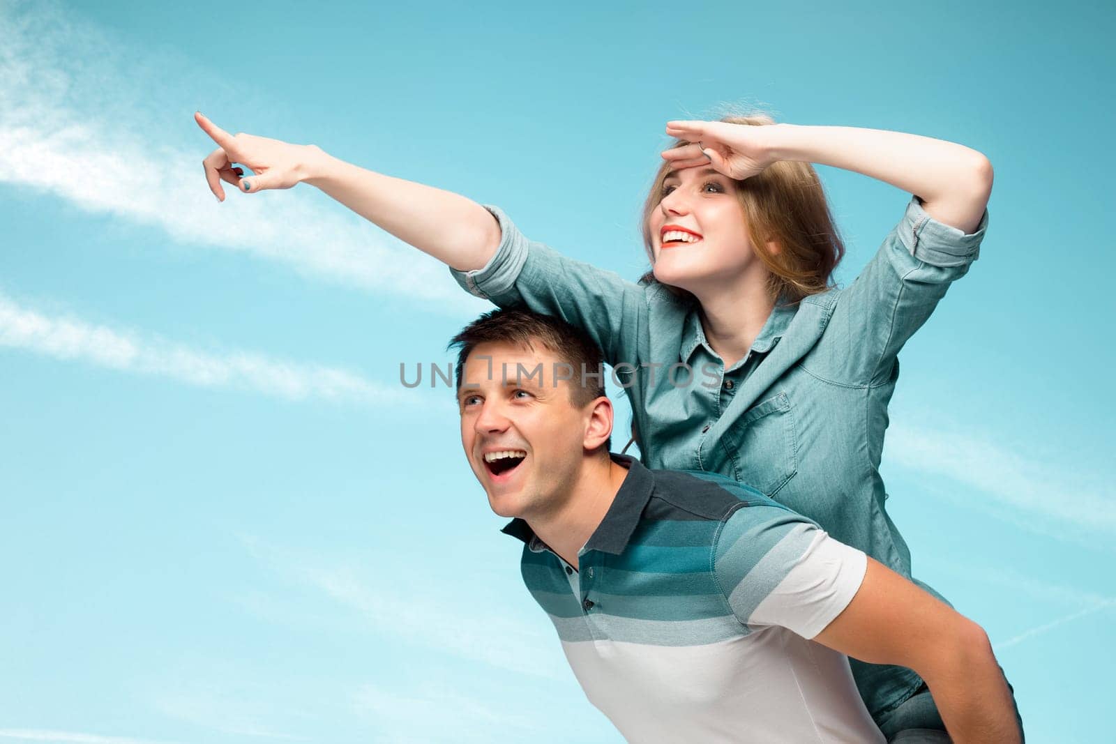 Young love Couple smiling under blue sky and looking away