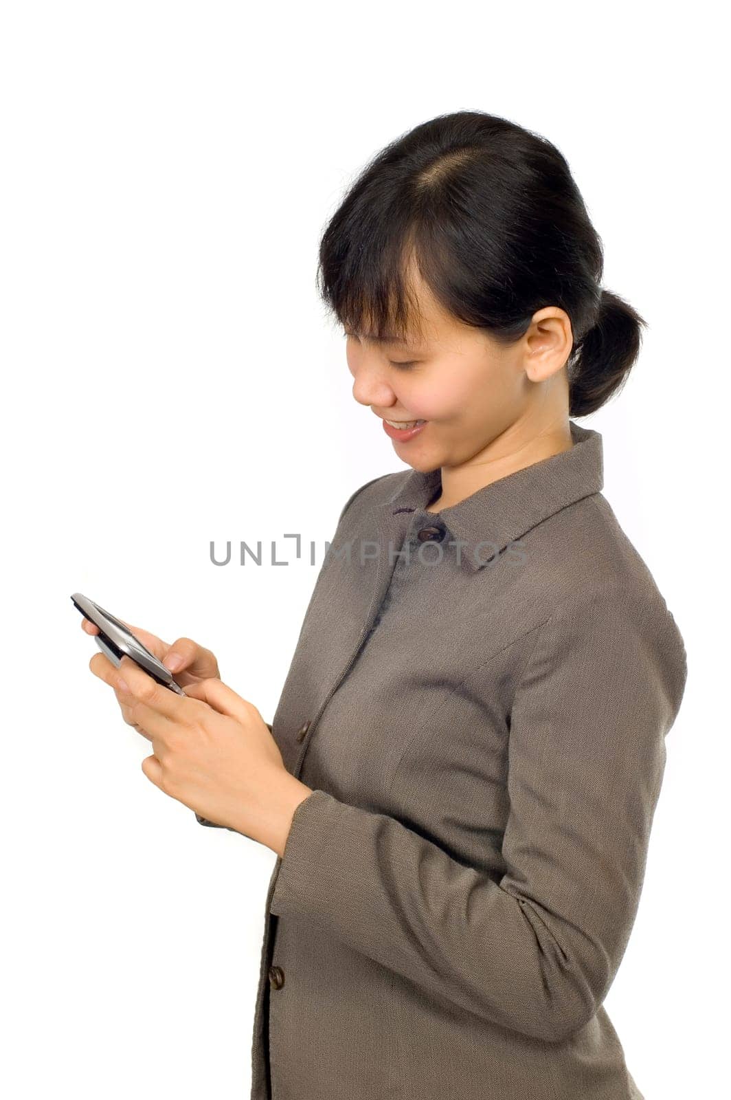 Pretty Asian Woman, text on her cellpone with happy face