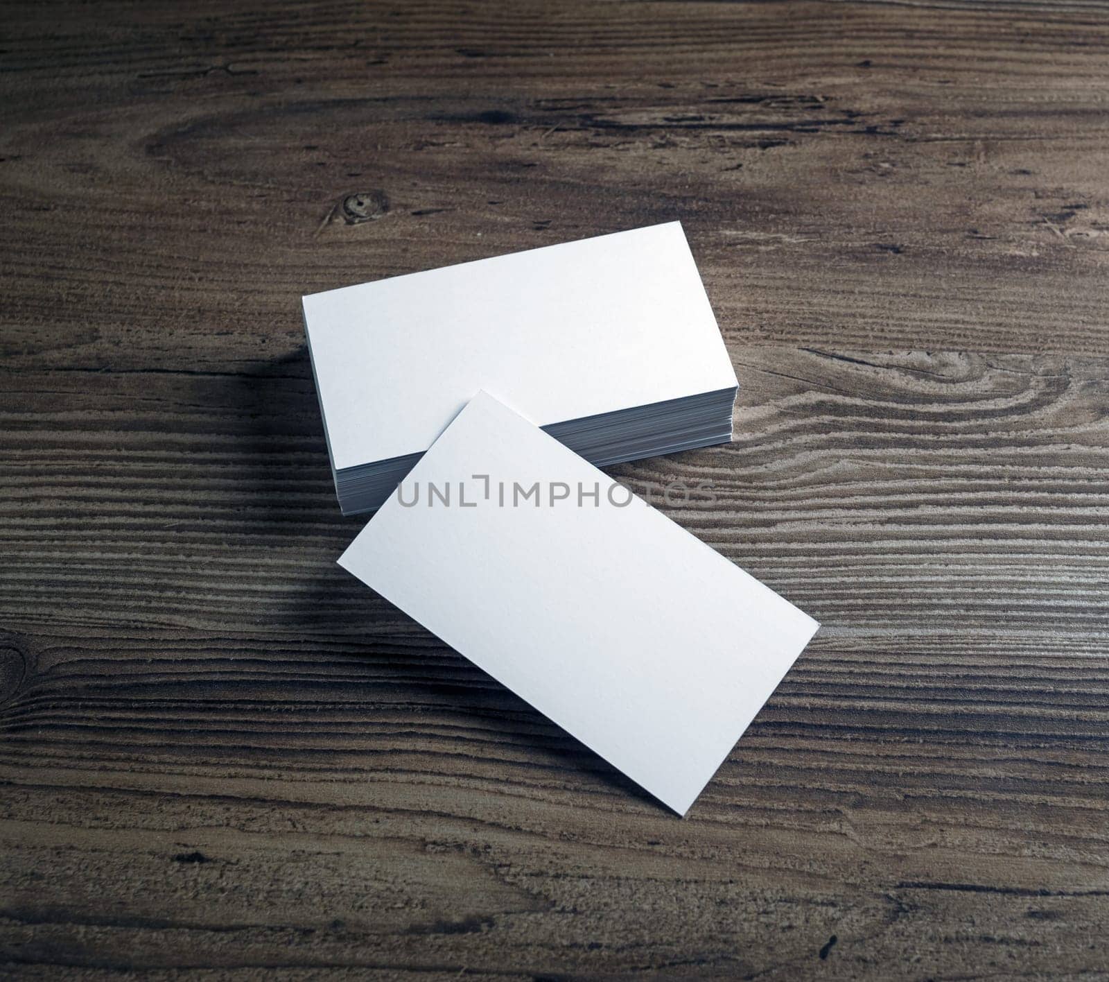 Photo of blank business cards on wooden table background. Presentation template for designers.