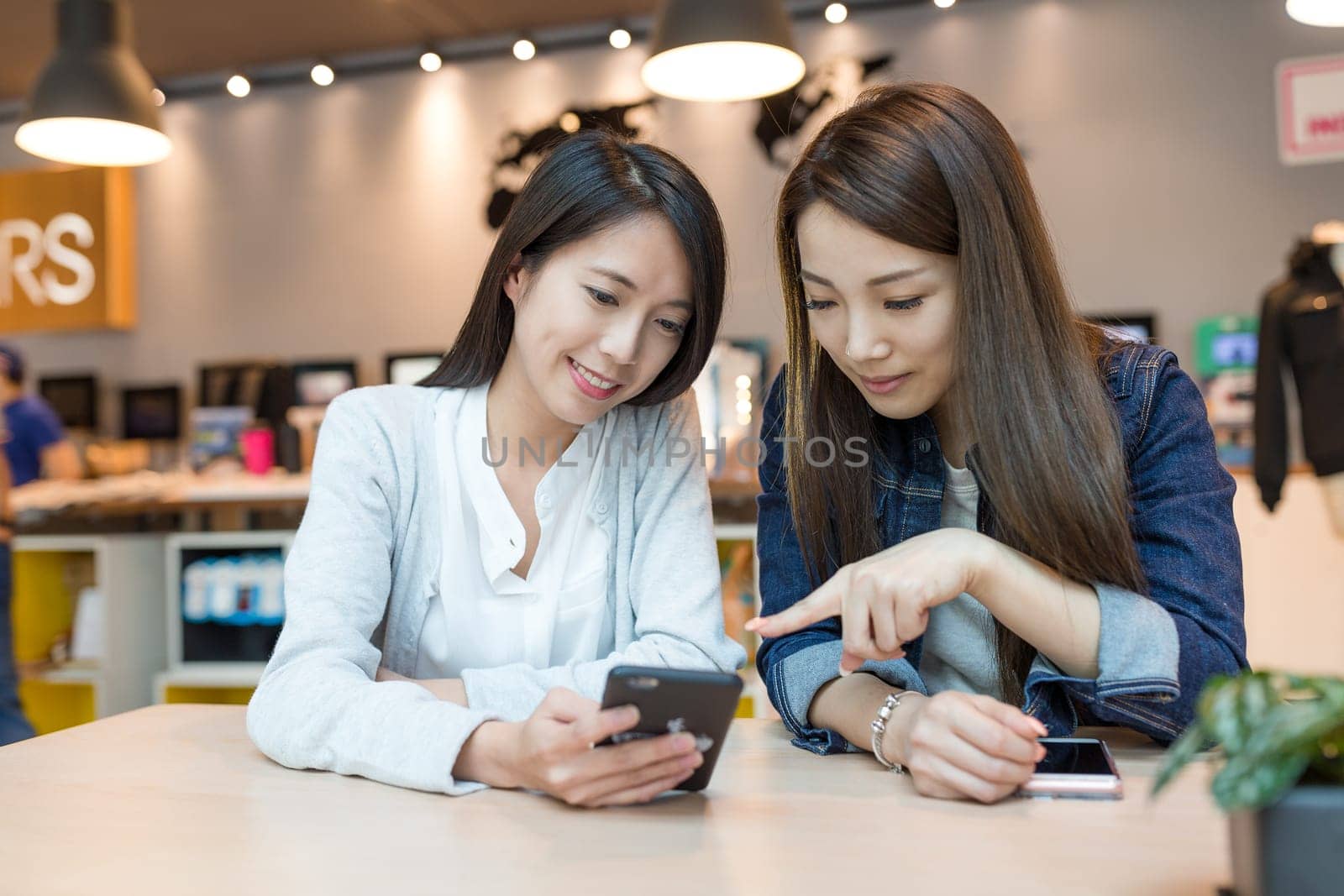 Grils Friends talking together with cellphone