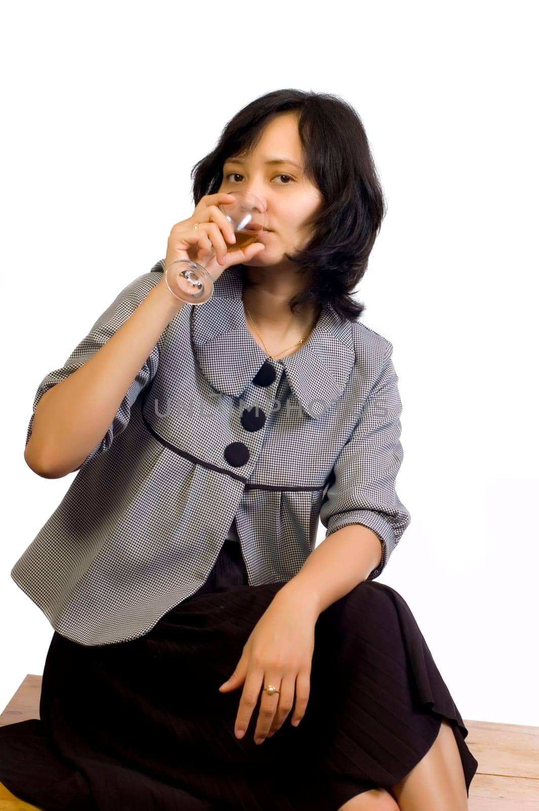Young beautiful asian business woman celebrating her success with wine and sit on the table