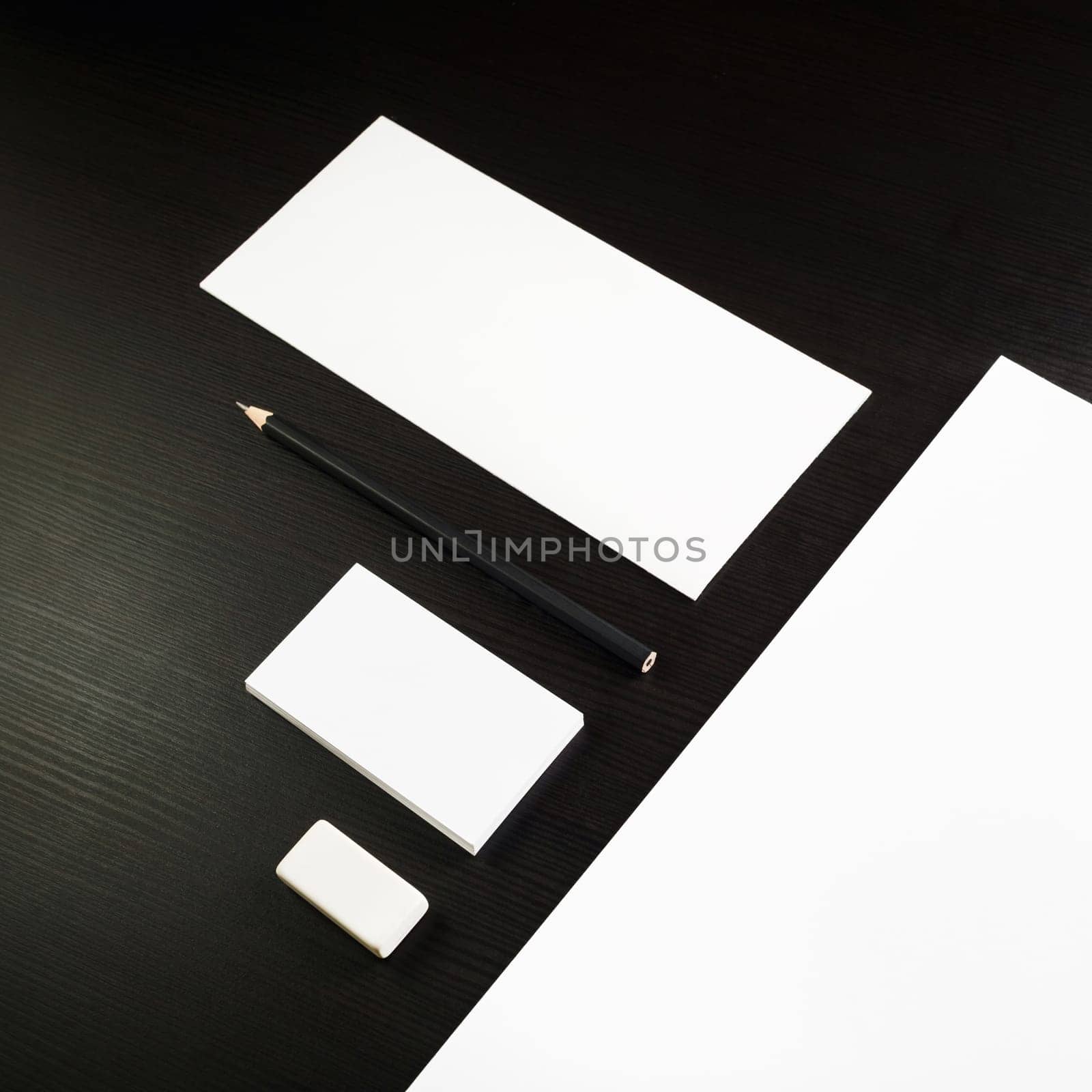 Photo of blank stationery set on black wooden table background. Corporate identity template for ID. Responsive design mockup.