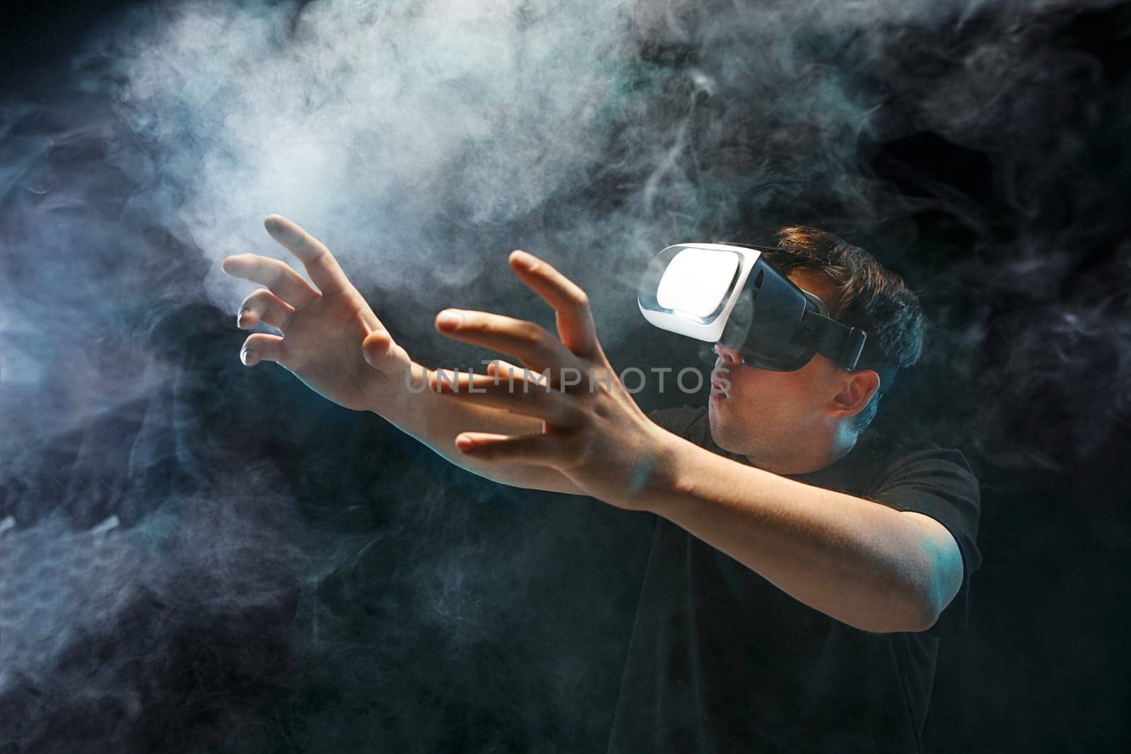 The man with glasses of virtual reality. Future technology concept. Black studio smoky background