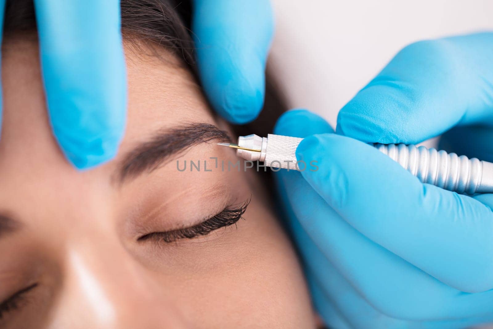 Close-up Of A Young Woman Getting Laser Treatment On Woman's Eyebrow In Beauty Spa