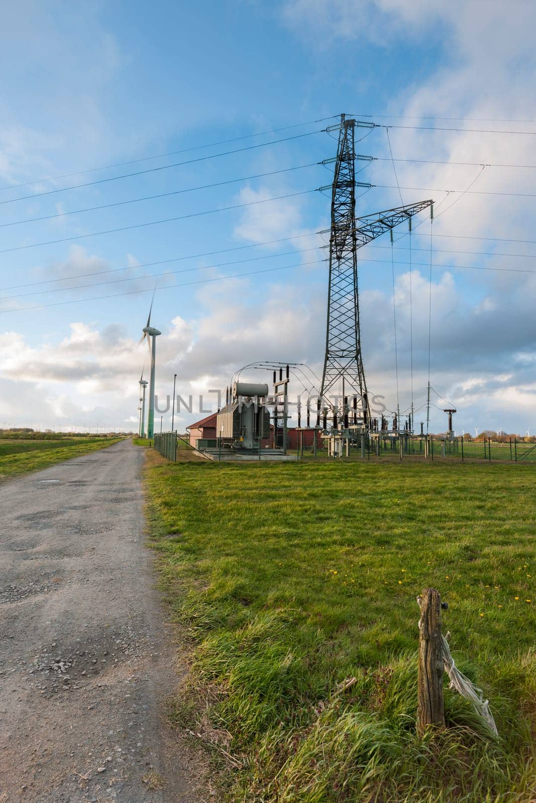 Landscape view in East Frisia with wind turbines,substation and high-voltage mast in the Abernd twilight.