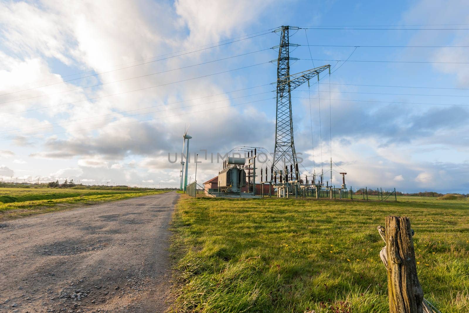 Landscape view in East Frisia with wind turbines,substation and high-voltage mast in the Abernd twilight.