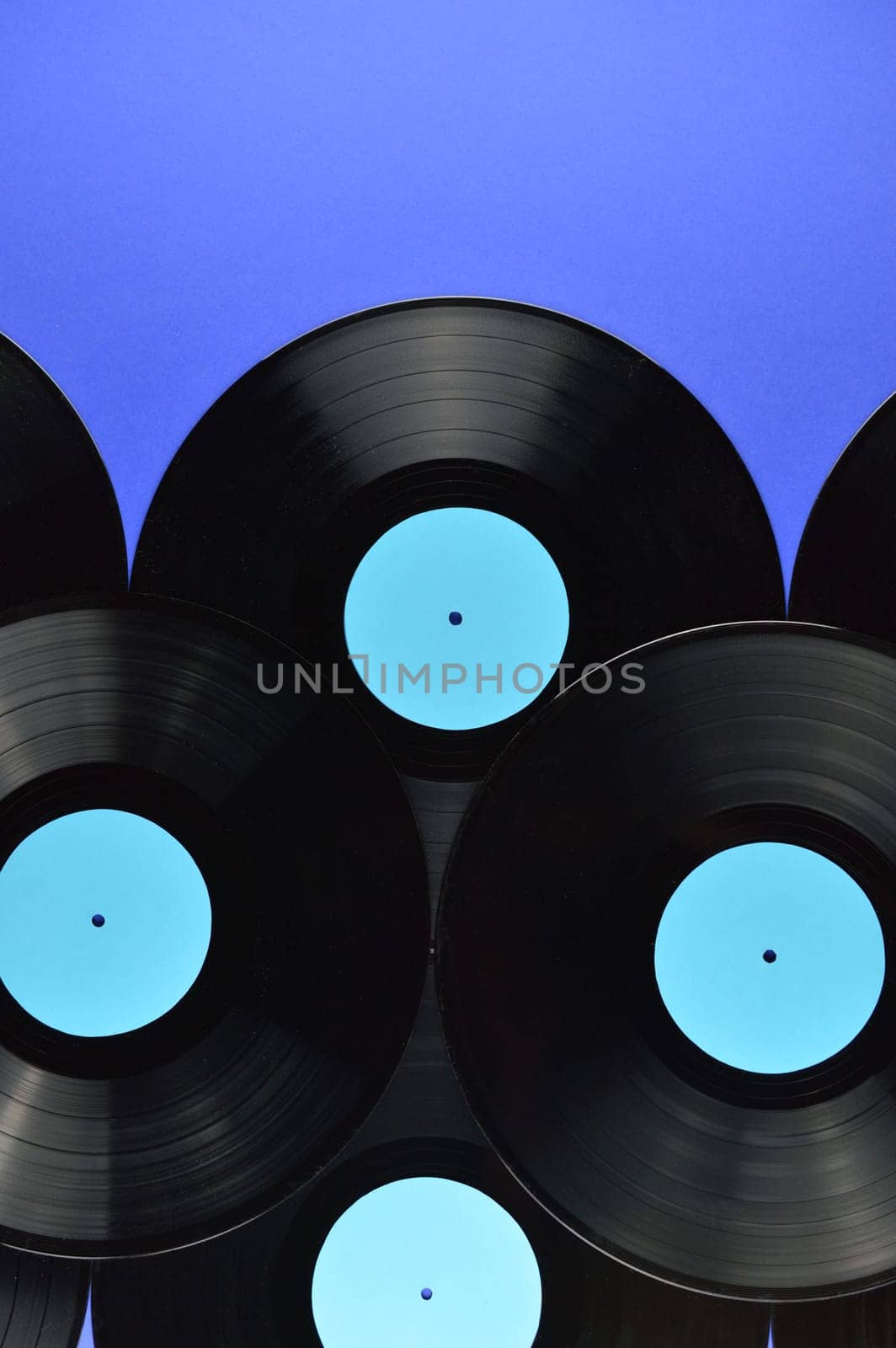border of old black vinyl records with blank cyan labels on blue background