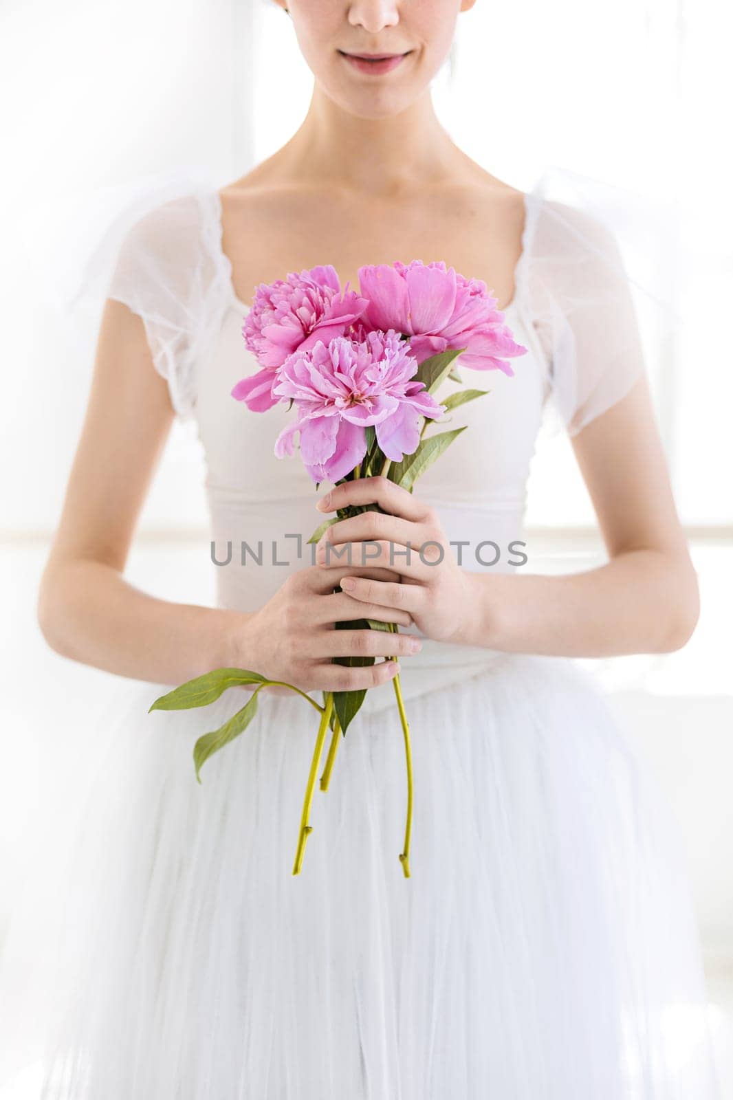 Portrait of a young bride with flowers on white studio