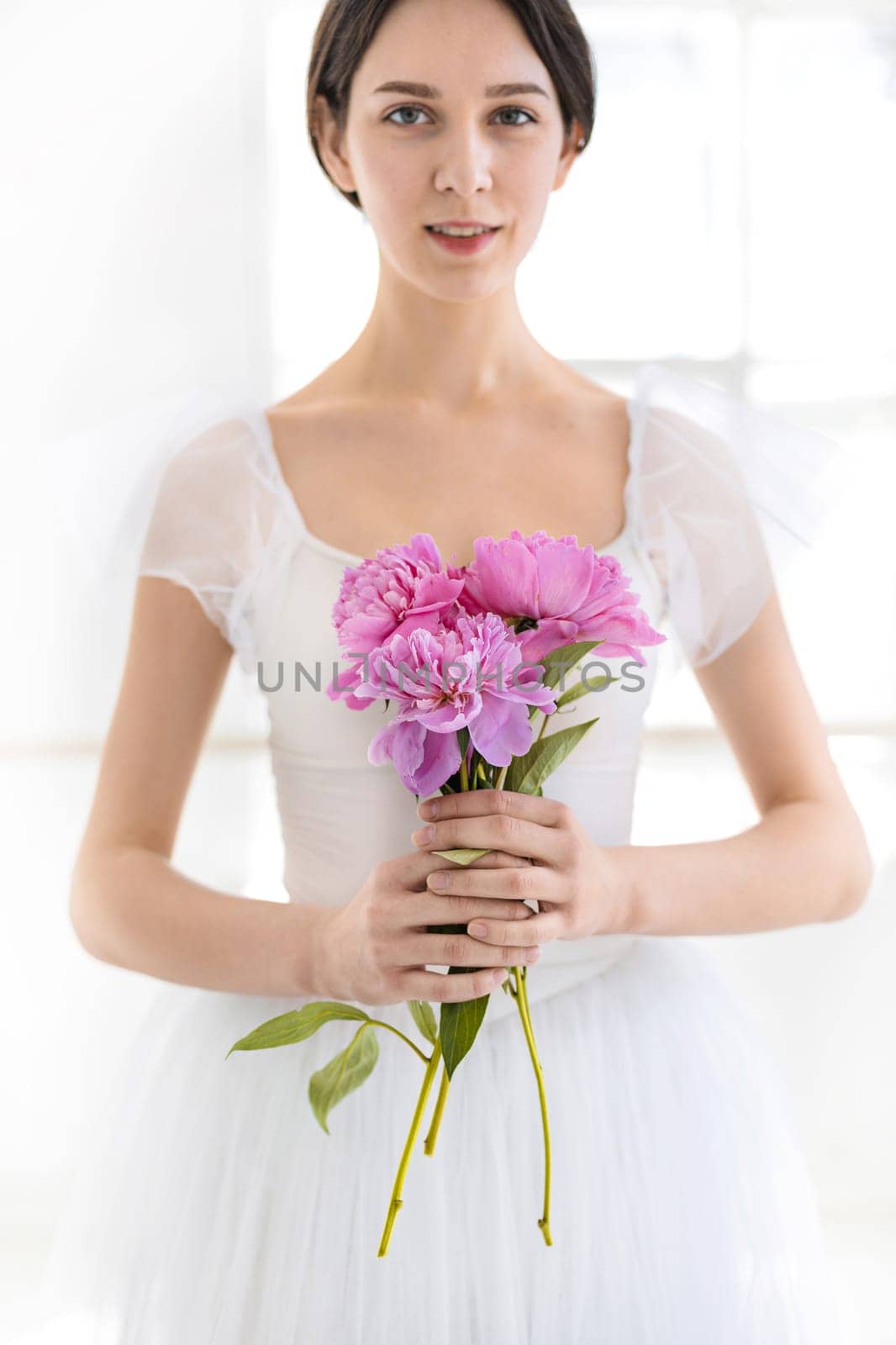 Portrait of a young bride with flowers on white studio