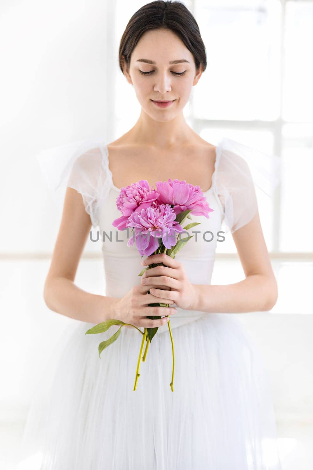 Portrait of a young bride with flowers on white studio