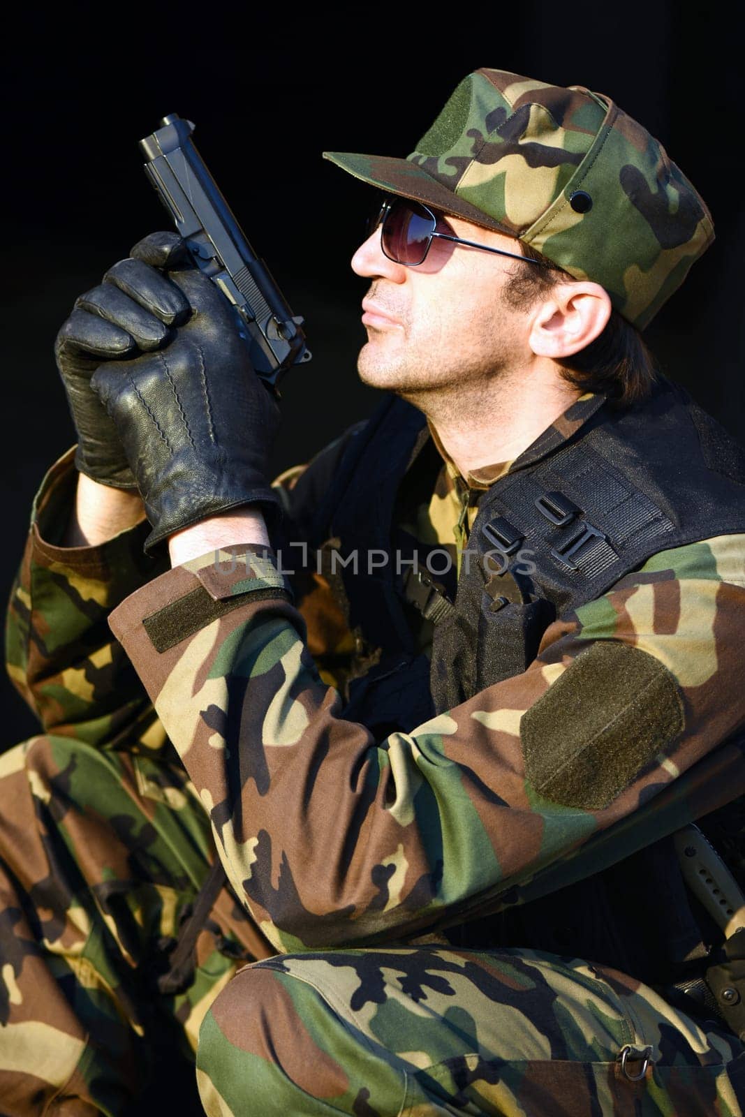The soldier is holding a handgun, profile view.