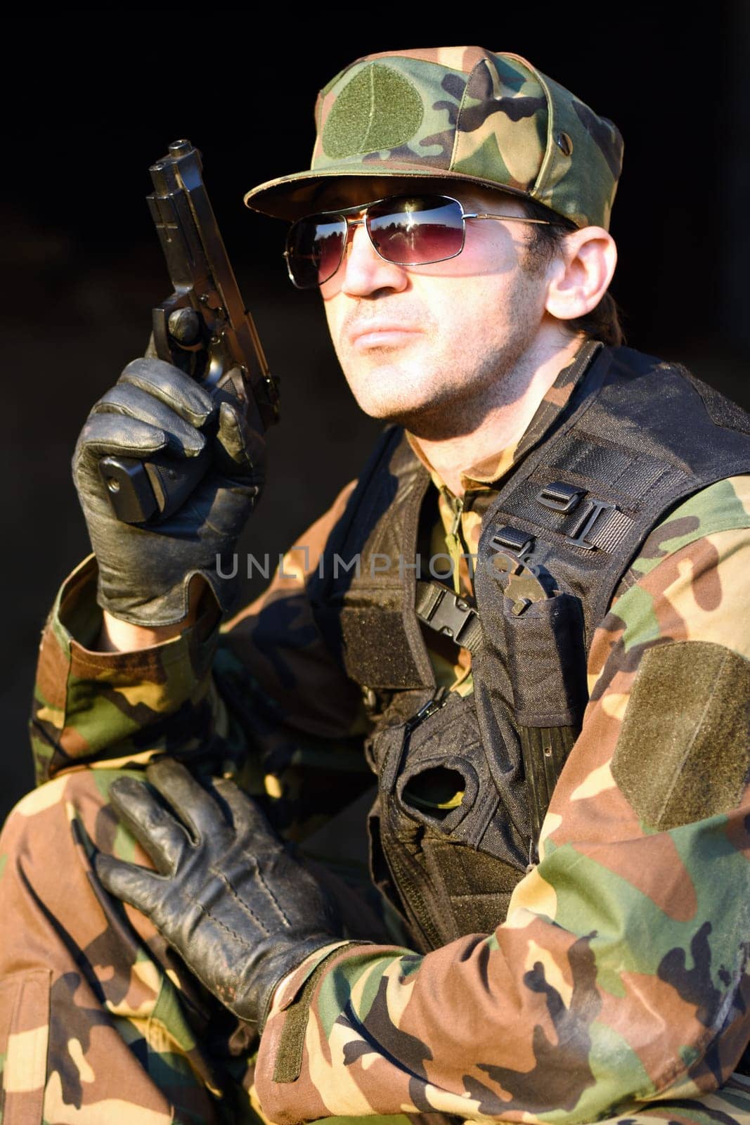 The soldier in uniform is holding the gun.