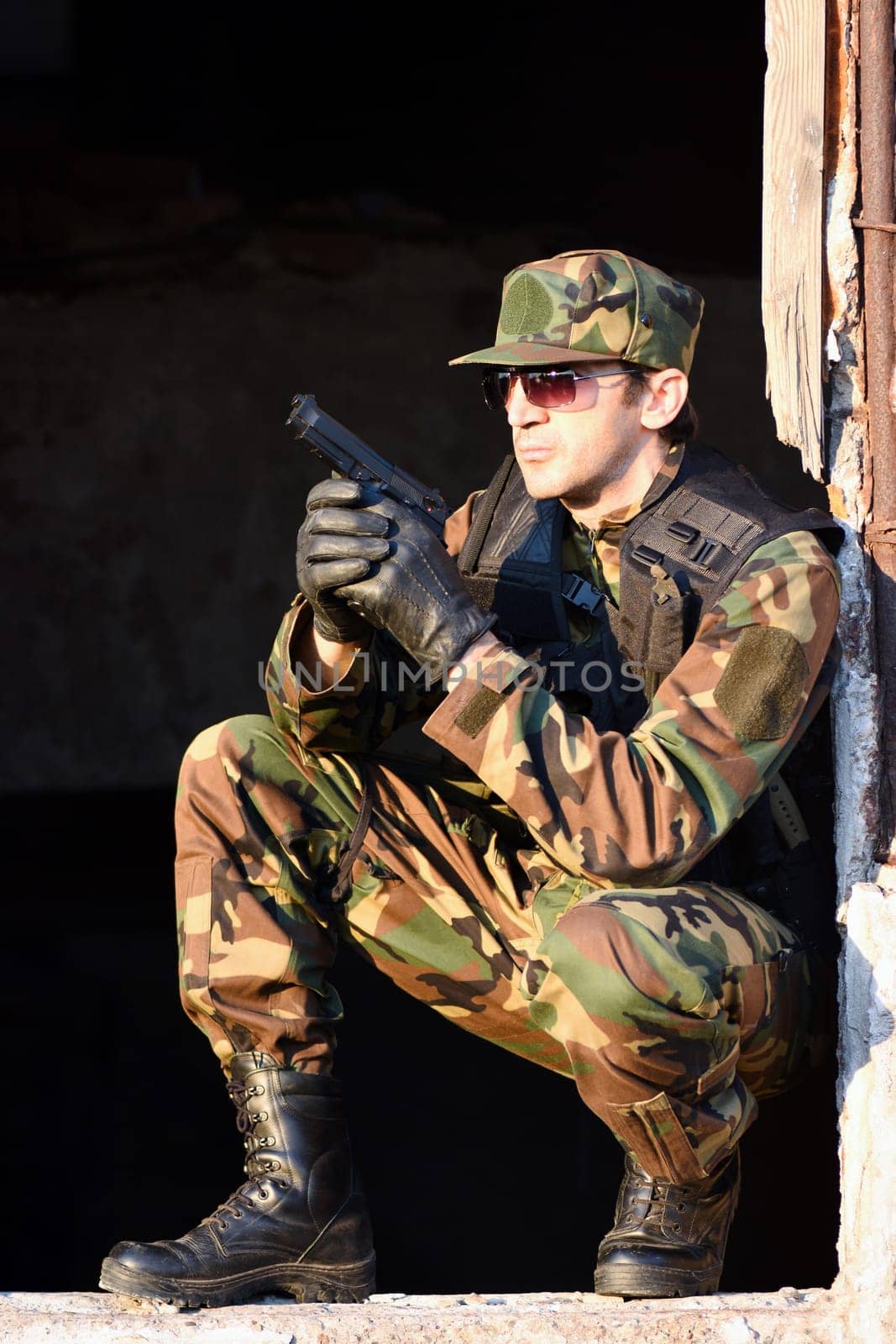 The soldier in uniform has a gun.