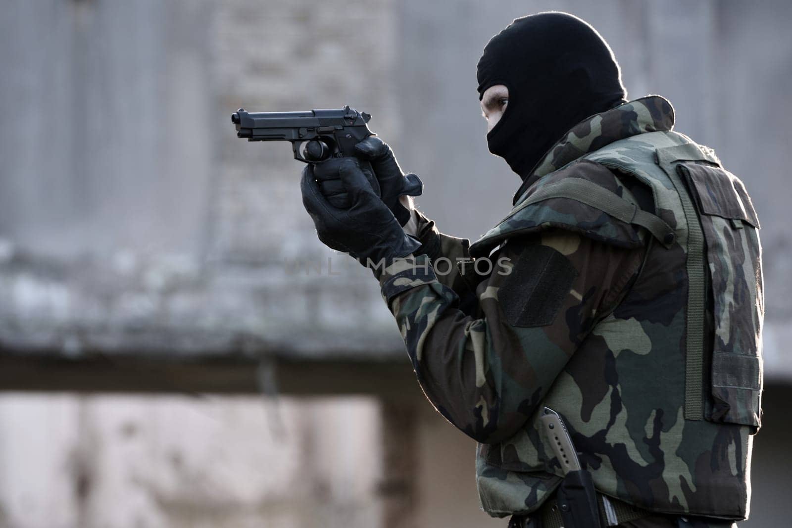 The soldier is shooting with the gun.