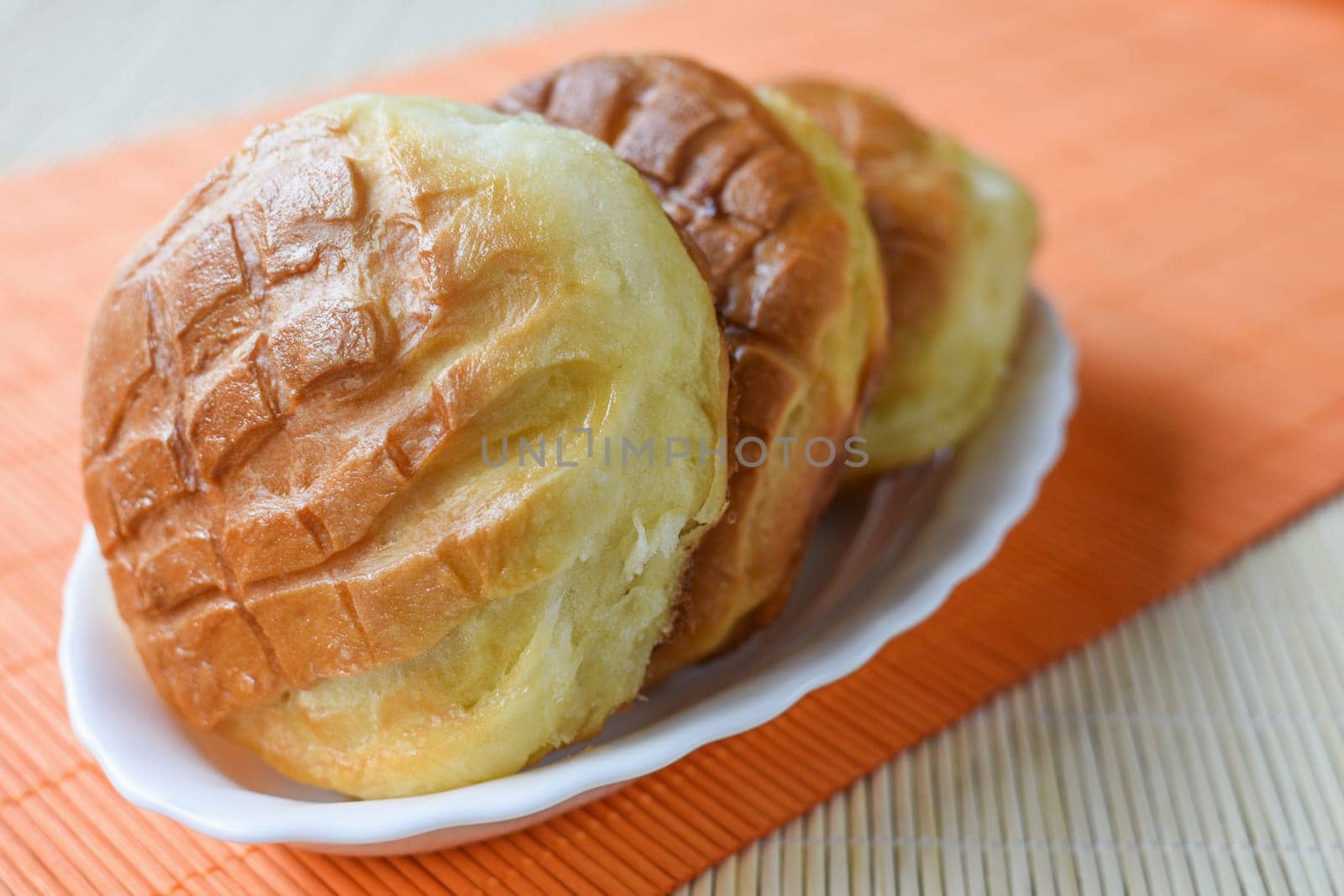 Three bannocks are in white dish on orange background.