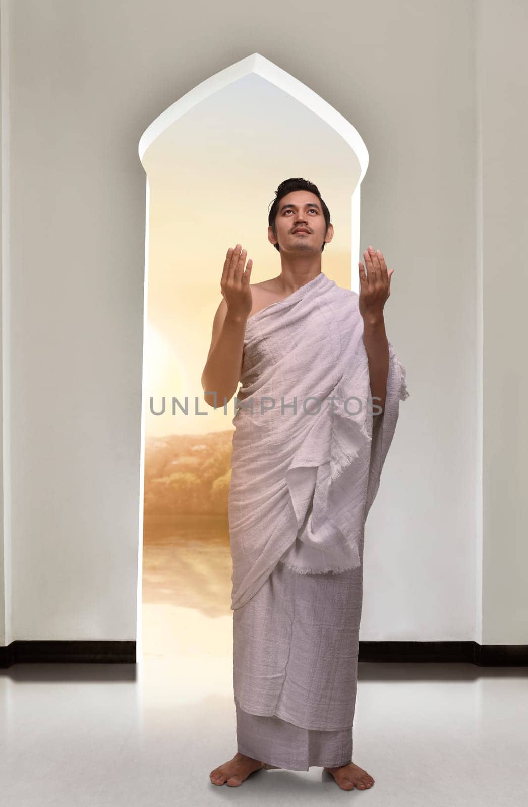 Handsome asian musim man wearing ihram and praying inside the mosque