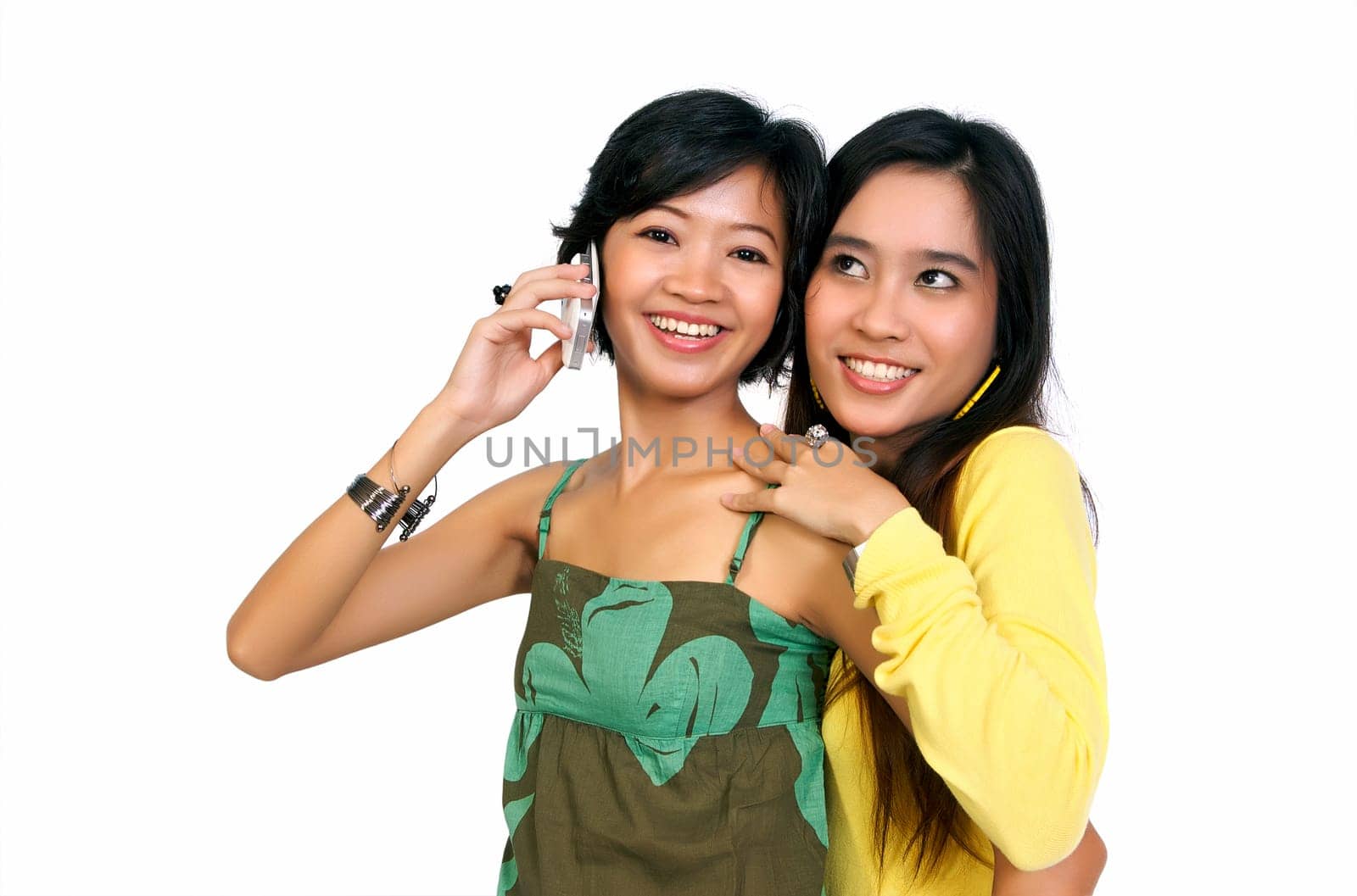 Two girls using cellphone isolated on white background