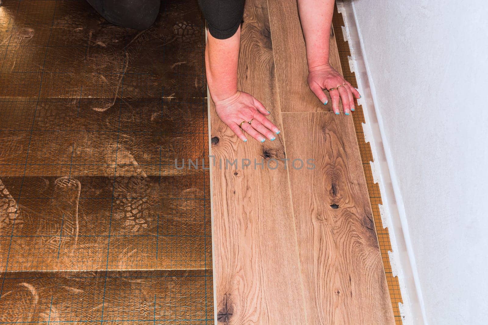 Woman in the installation of laminate made of plastic or vinyl...