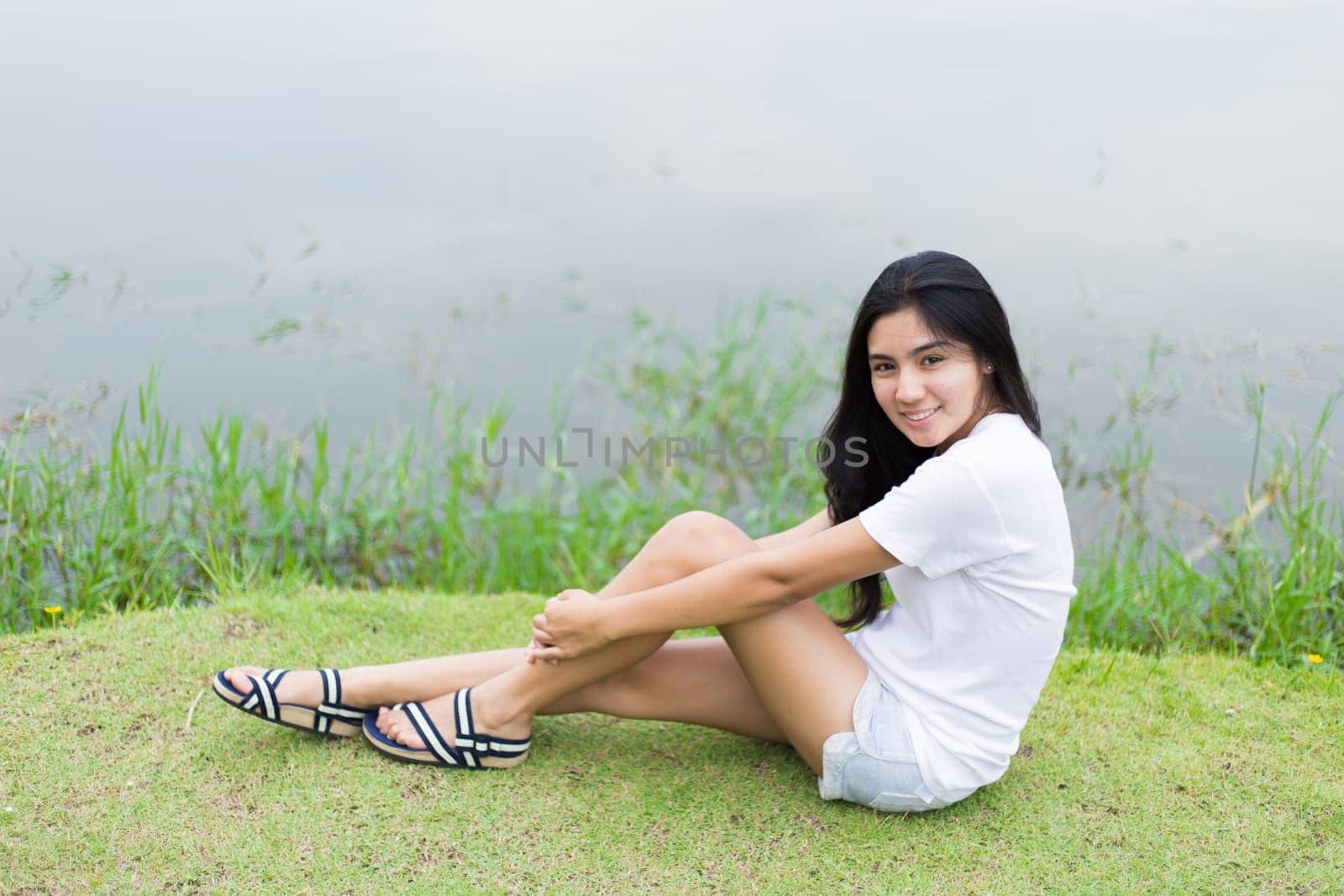 Asian woman is sitting on the rock in the park