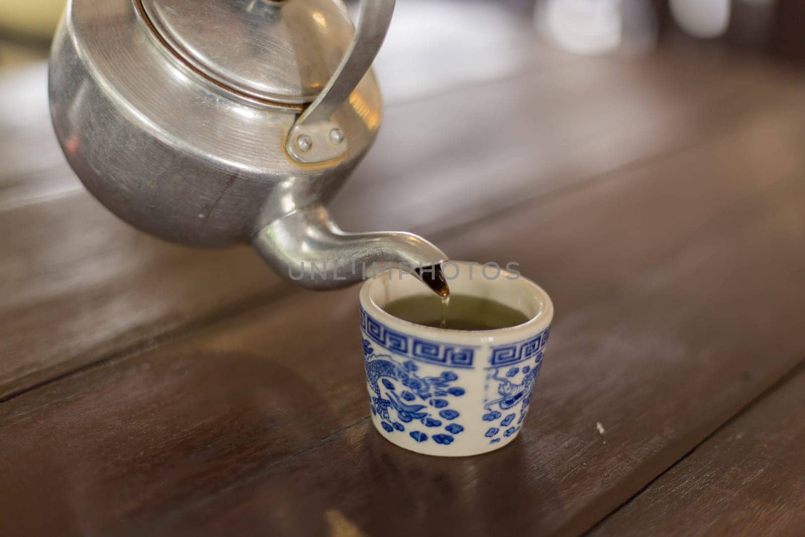Teapot pouring tea into a cup
