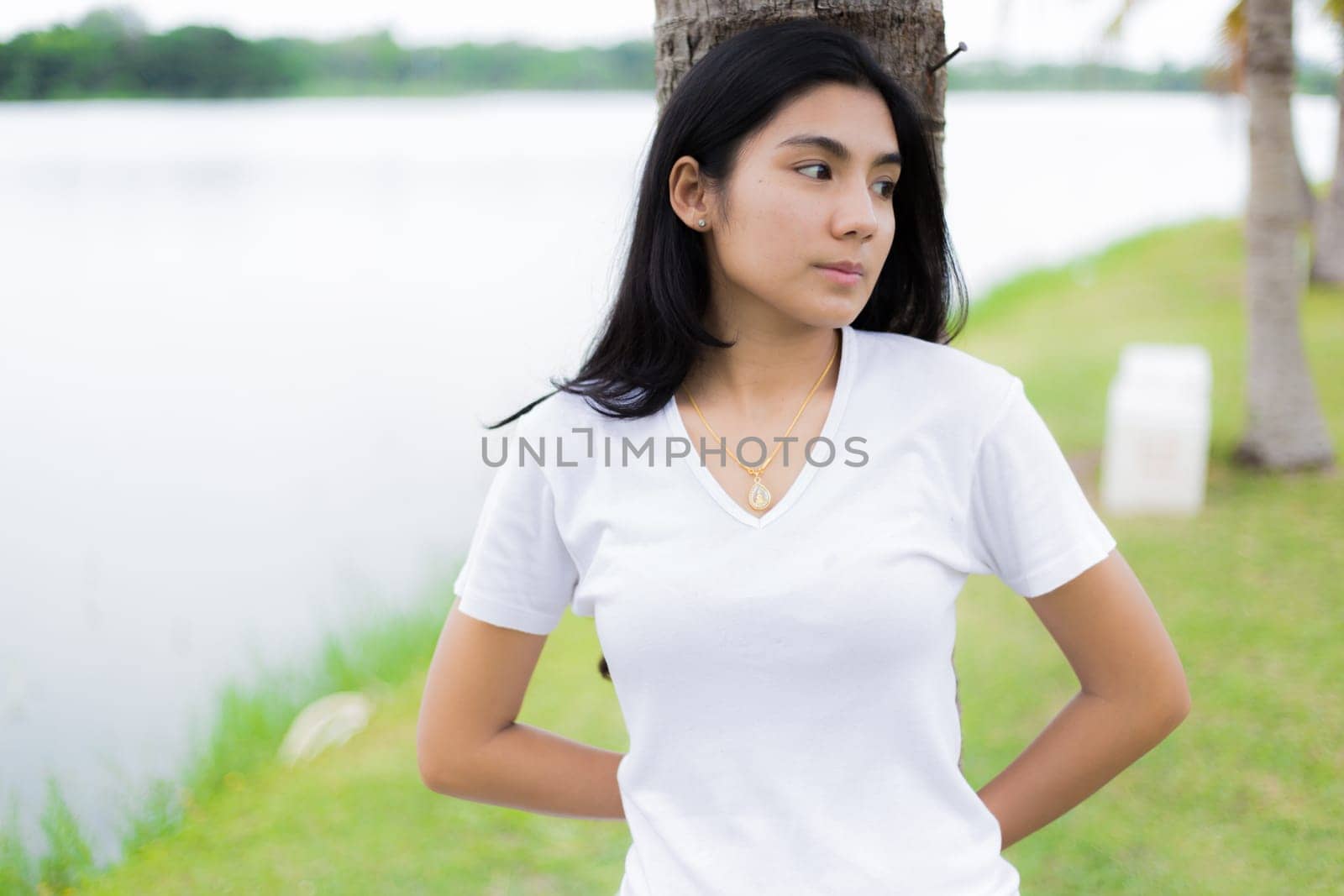 Asian woman is sitting on the rock in the park