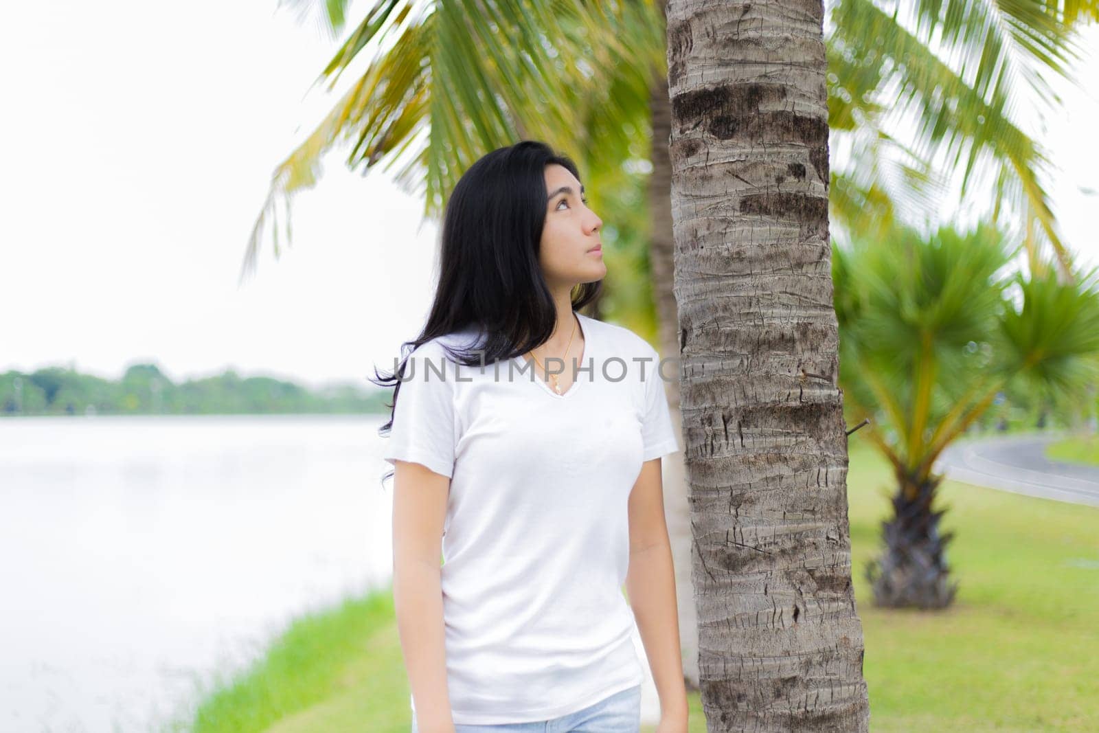 Asian woman is sitting on the rock in the park