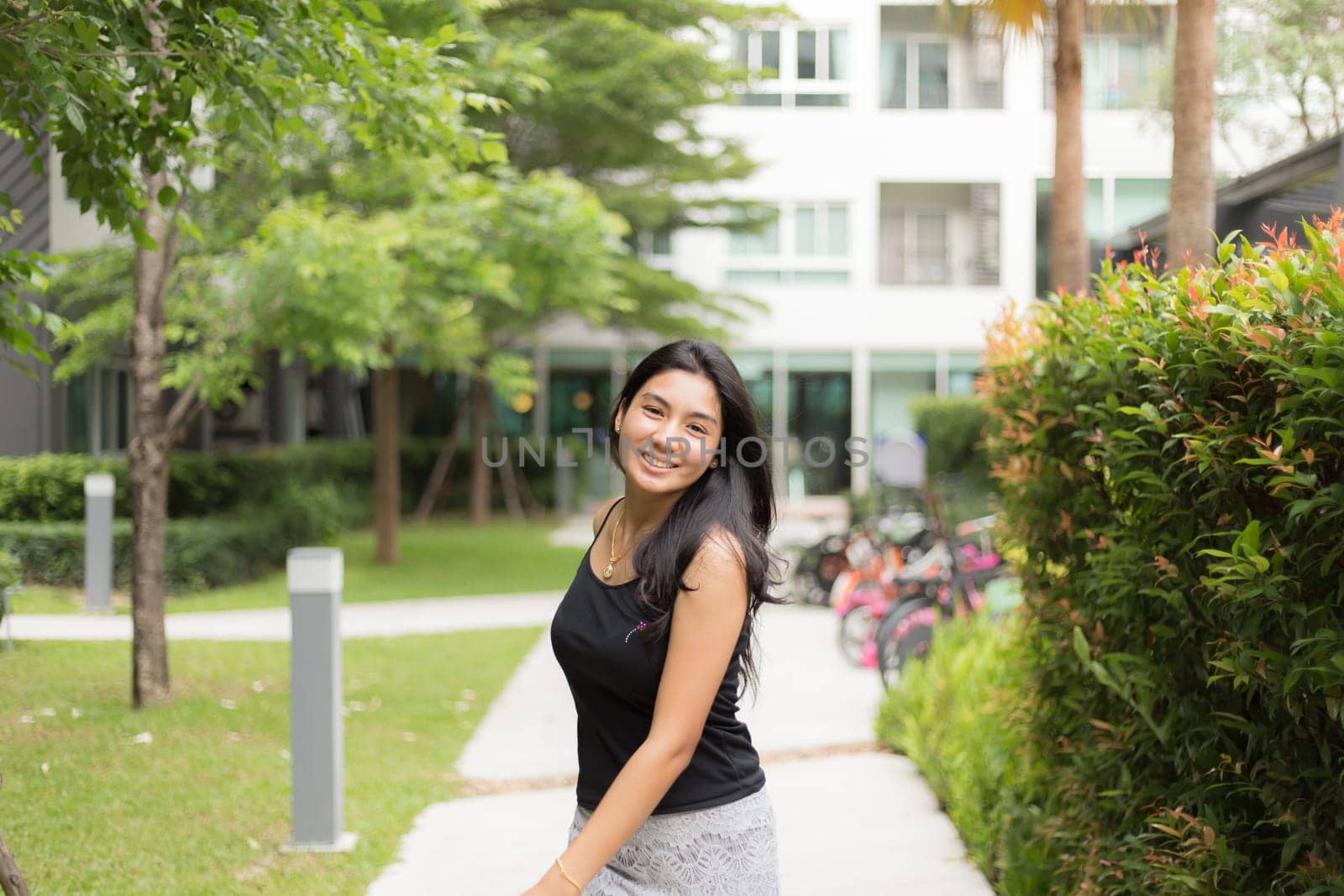 A portrait of a young asian woman walking on the park