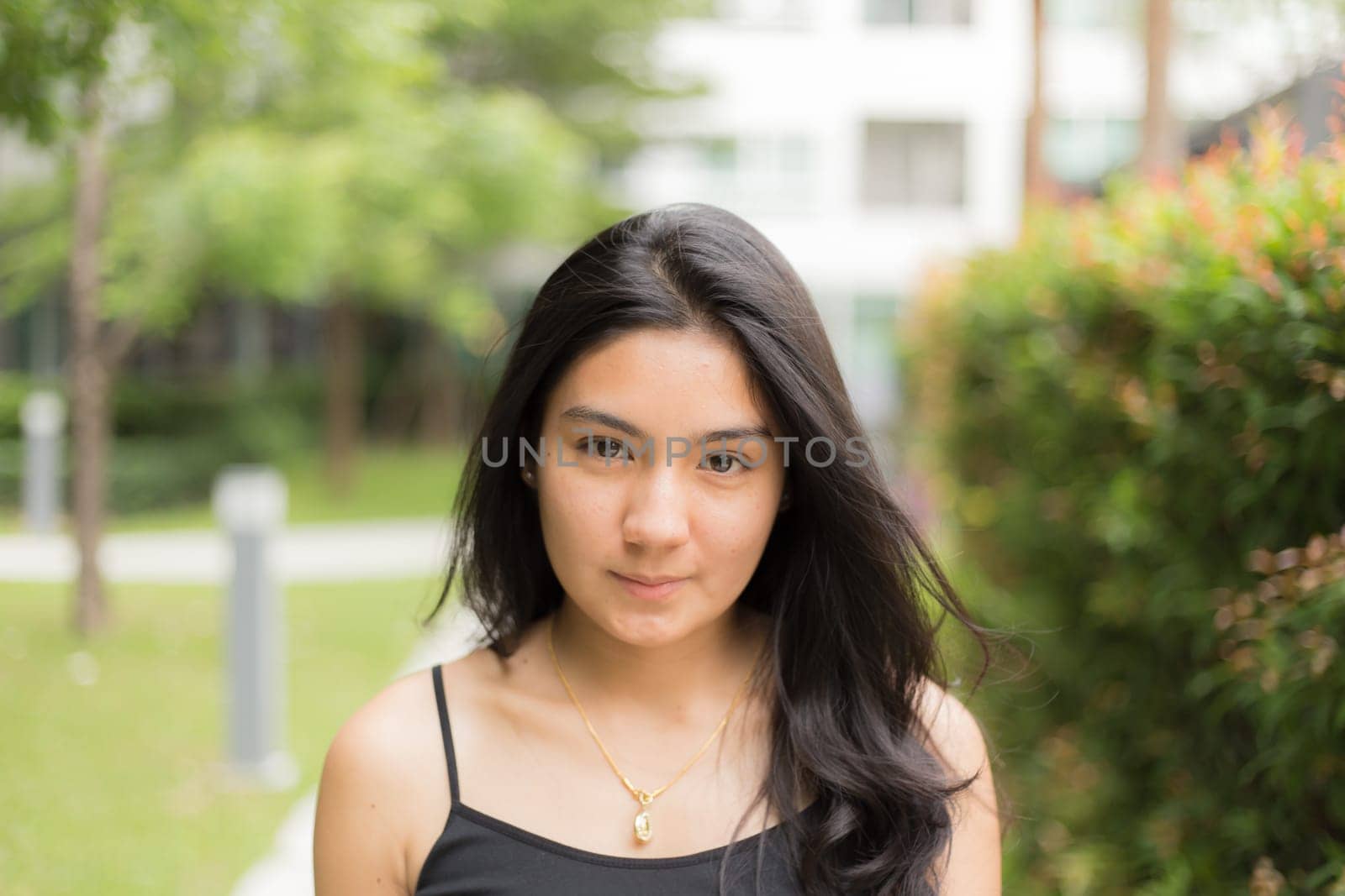 A portrait of a young asian woman walking on the park