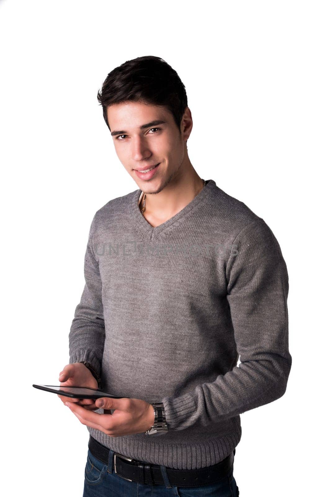 Smiling young man holding ebook reader and looking at camera, standing isolated on white background