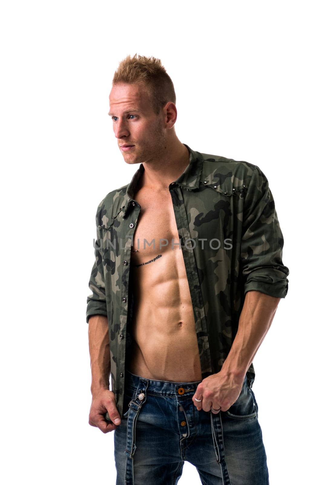 Muscular young male model wearing camouflage jacket on naked chest, isolated on white, looking away