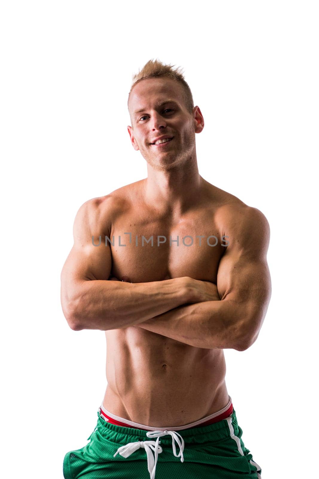 Fit shirtless male model smiling, posing with a lot of confidence, arms crossed on his chest, isolated on white