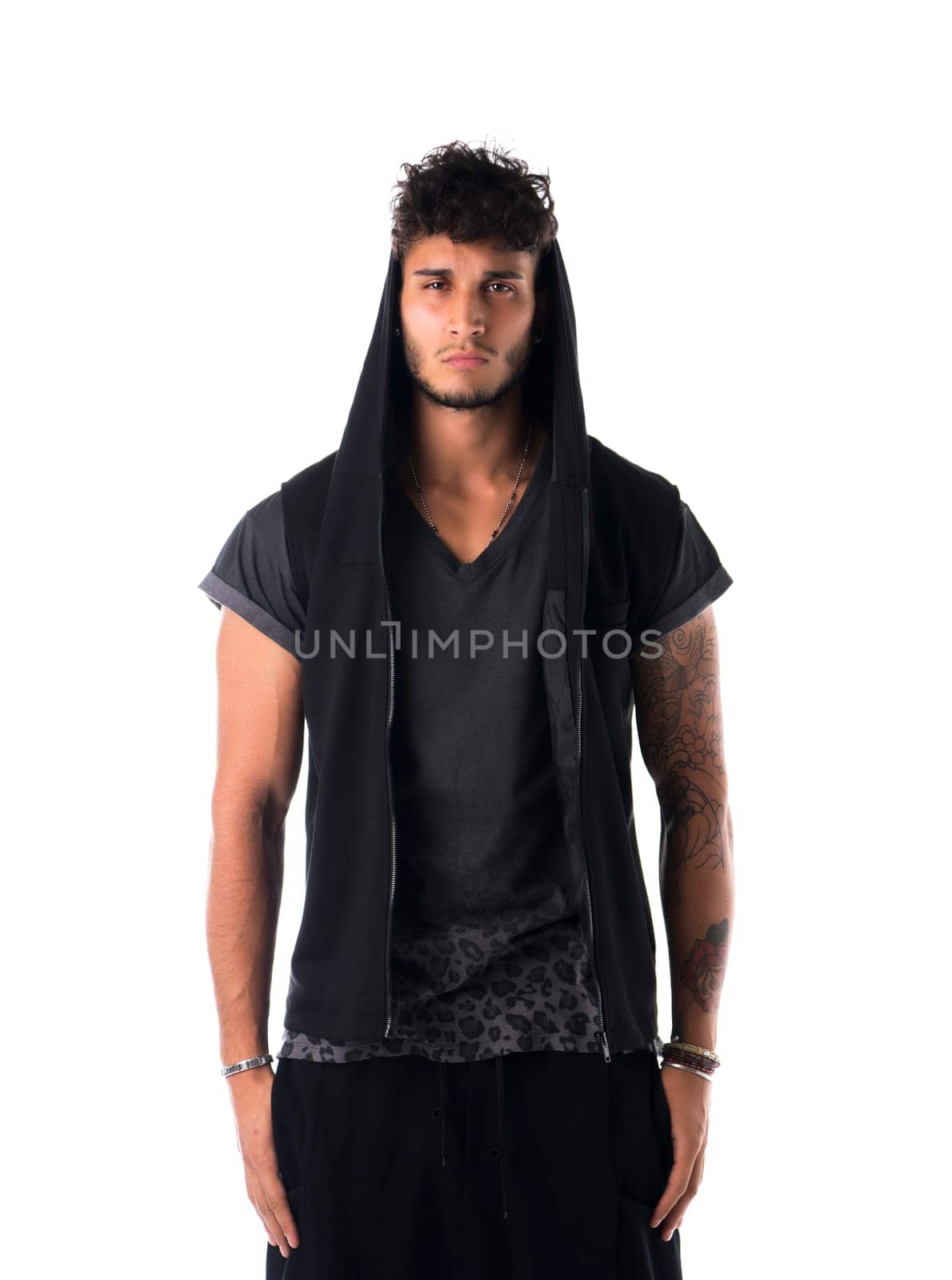 Portrait of handsome tough young man in dark hoodie isolated on white background, looking at camera