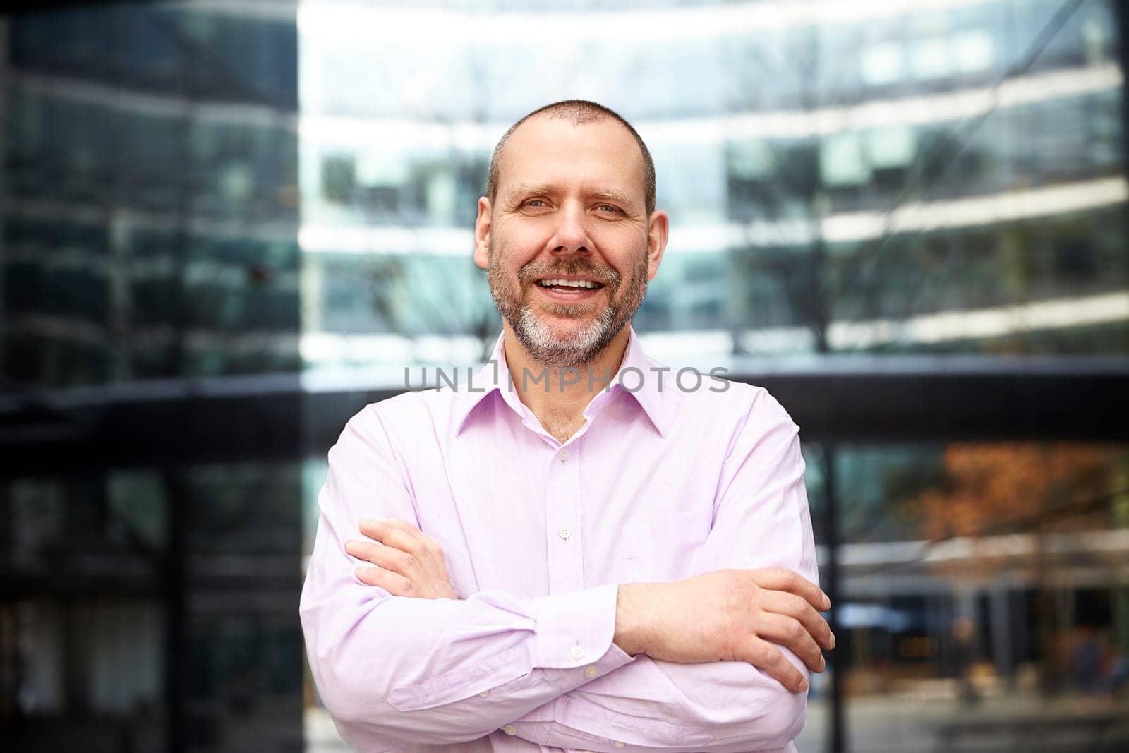 Cheerful businessman standing in front of his office.