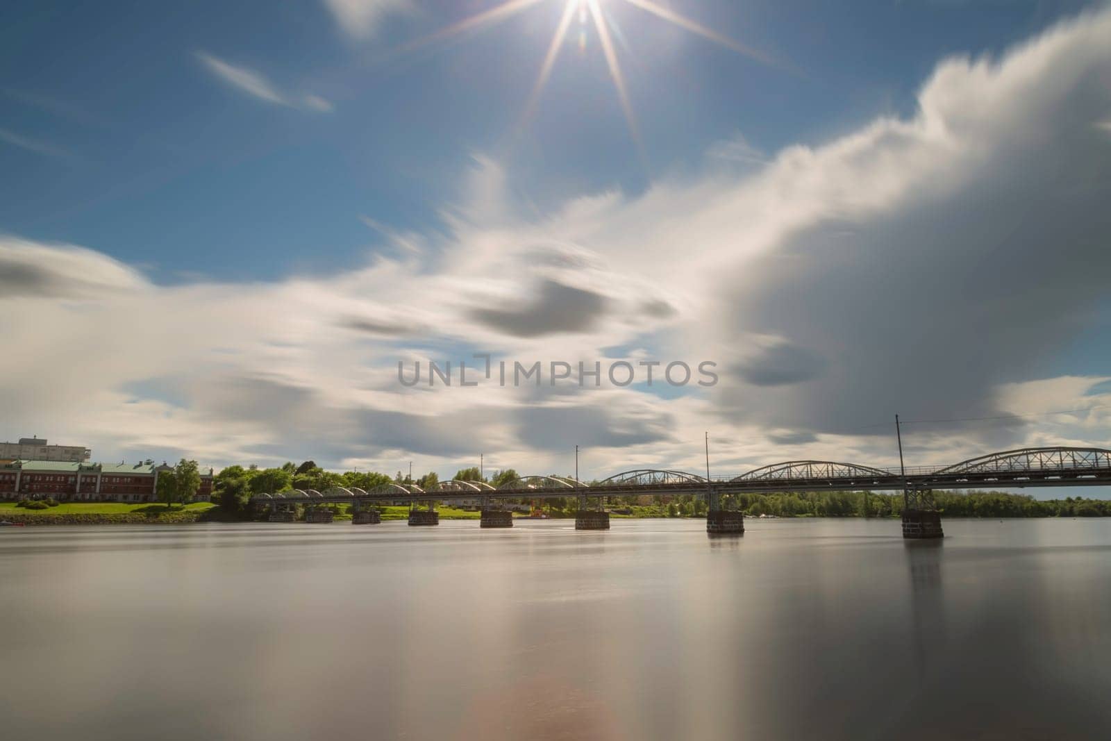 Bride over River in Umea, Sweden with a partly cloudy sky.