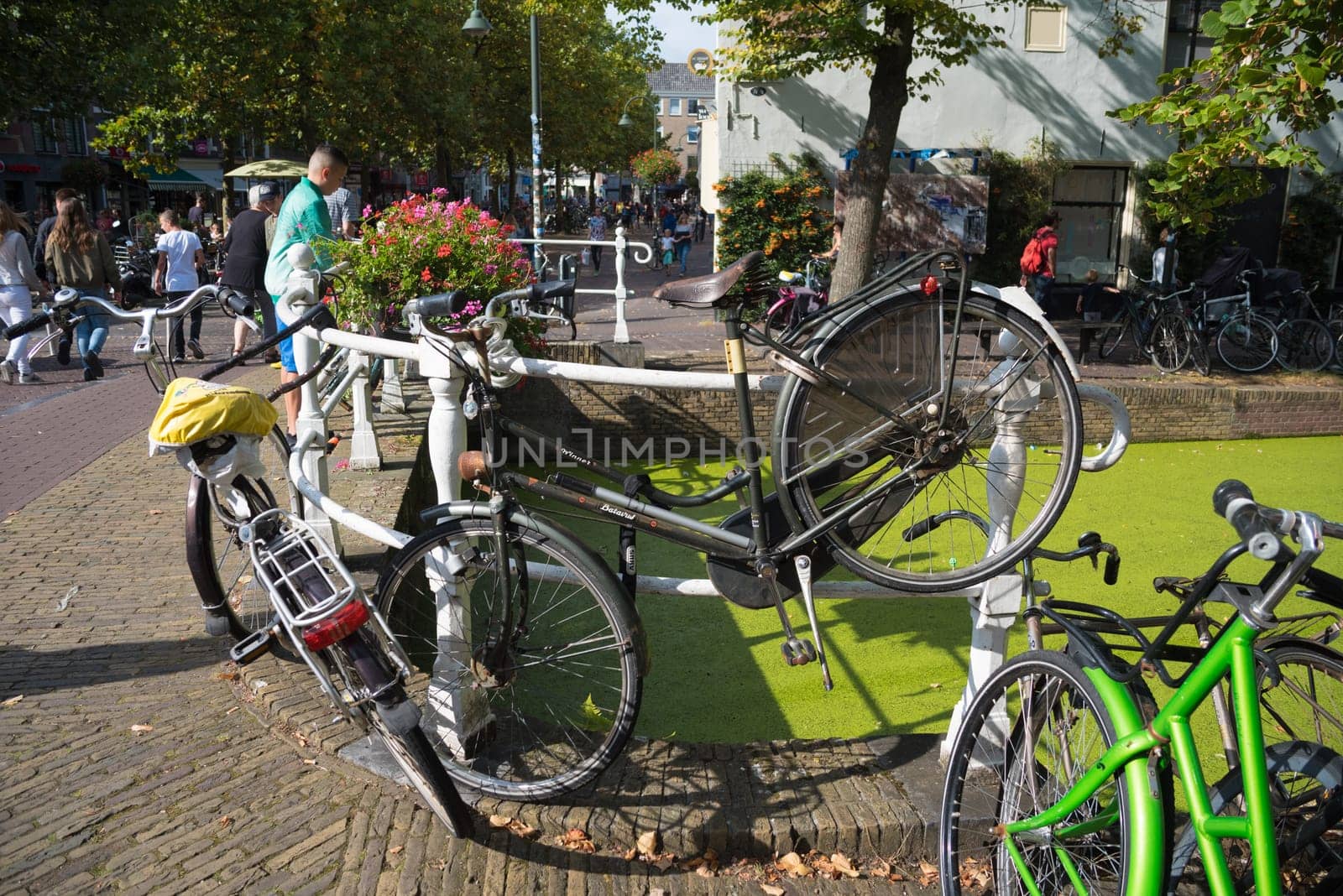 DELFT, NETHERLANDS - SEPTEMBER 18, 2016: Various bicycles parked on a small bridge in the center of Delft
