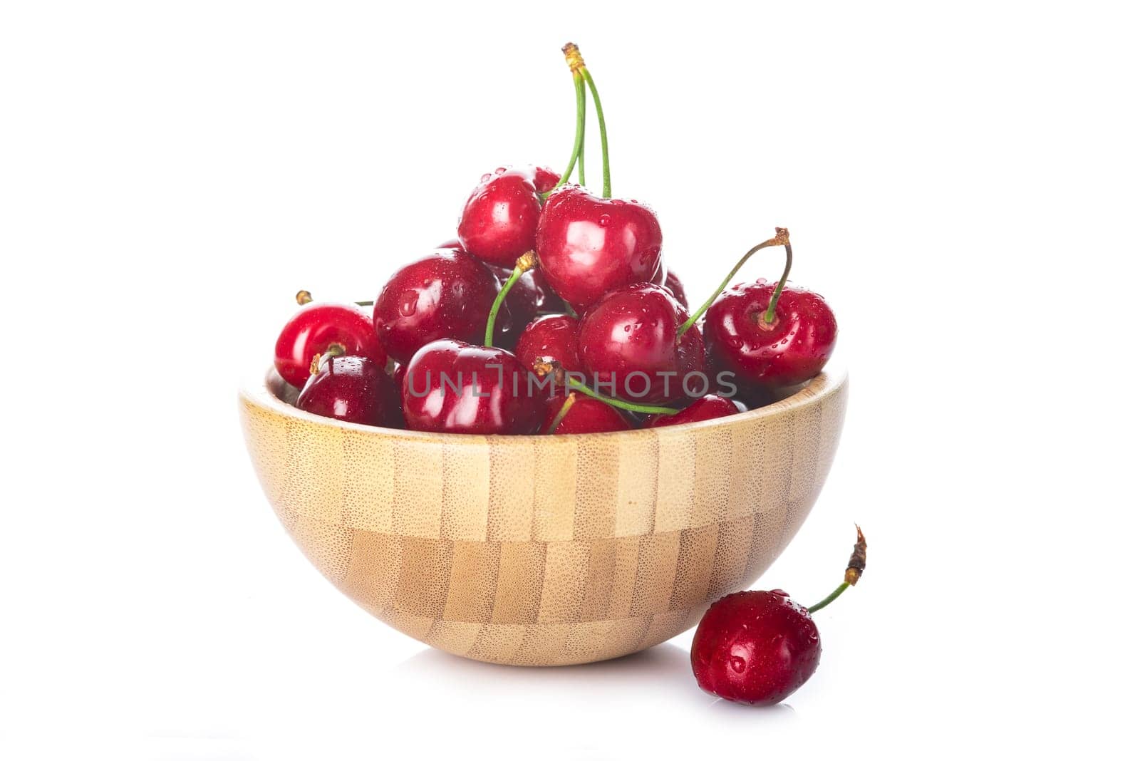 Wooden bowl with fresh cherries isolated on a white background