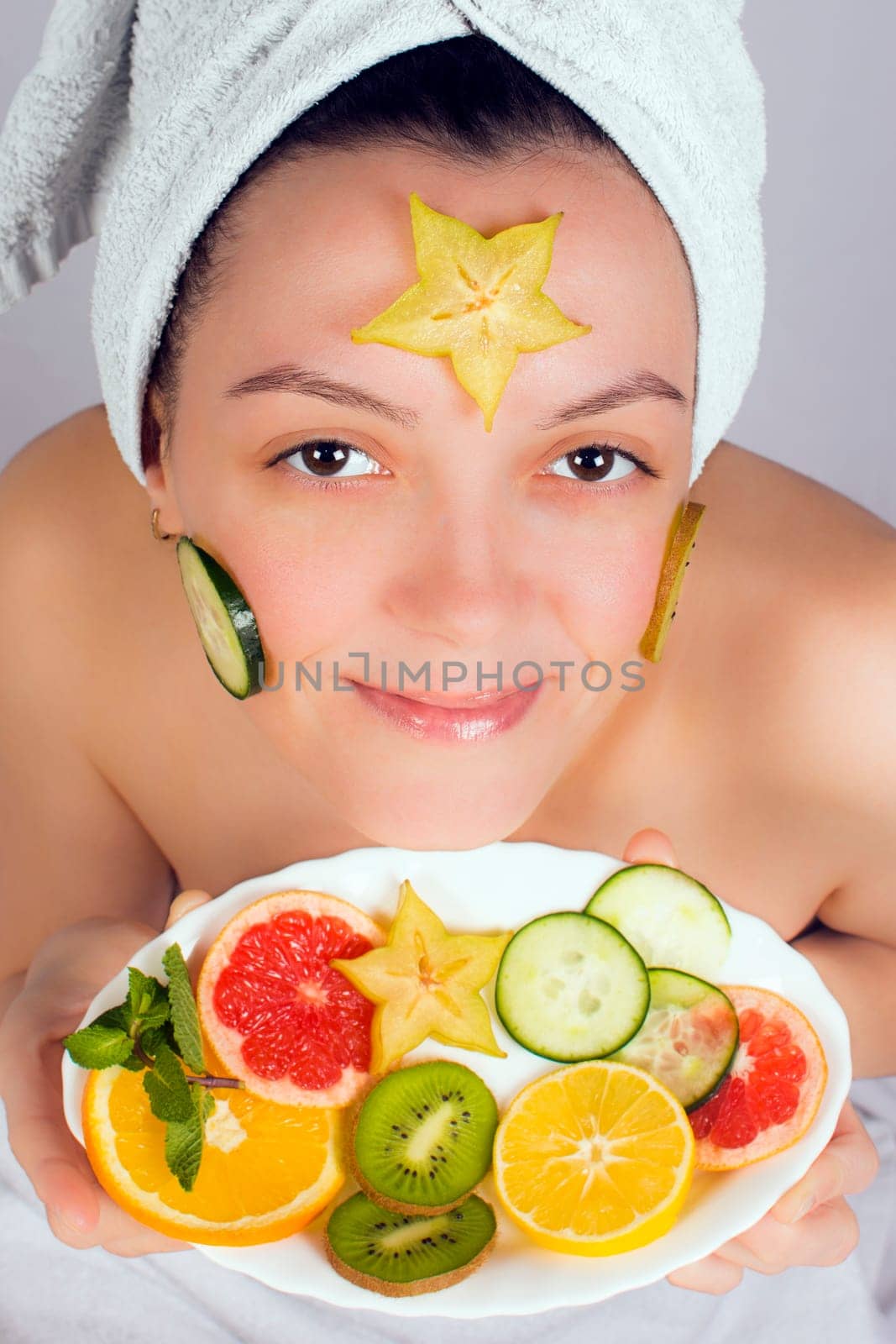Young woman has a fruit beauty treatment on her face.