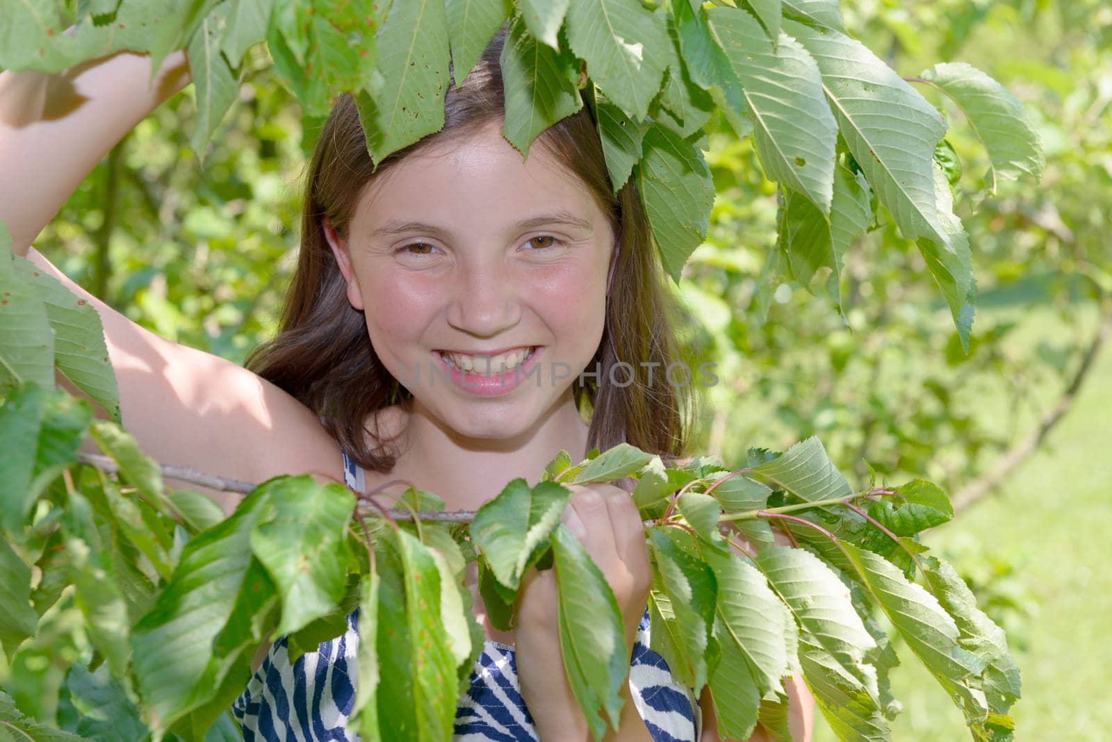 Portrait of beautiful young  smiling teen girl, in the foliage