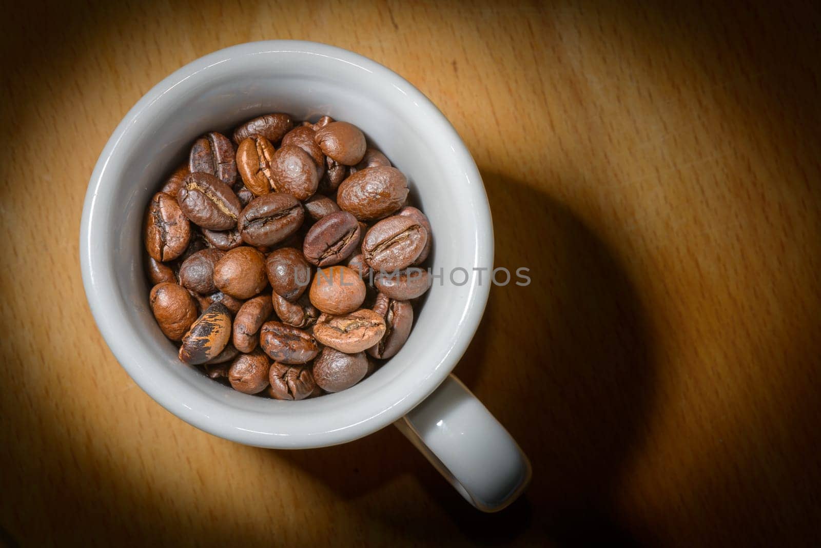 Nice cup of coffe with toasted coffee seeds inside on wood background