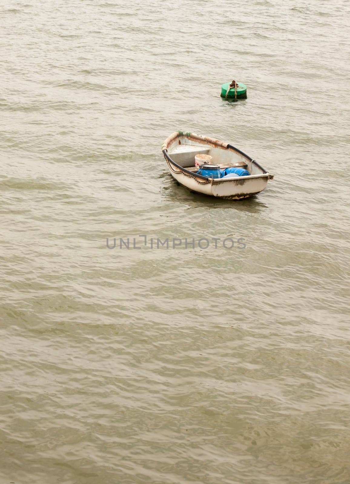 a single wooden boat no people in a grey sea alone