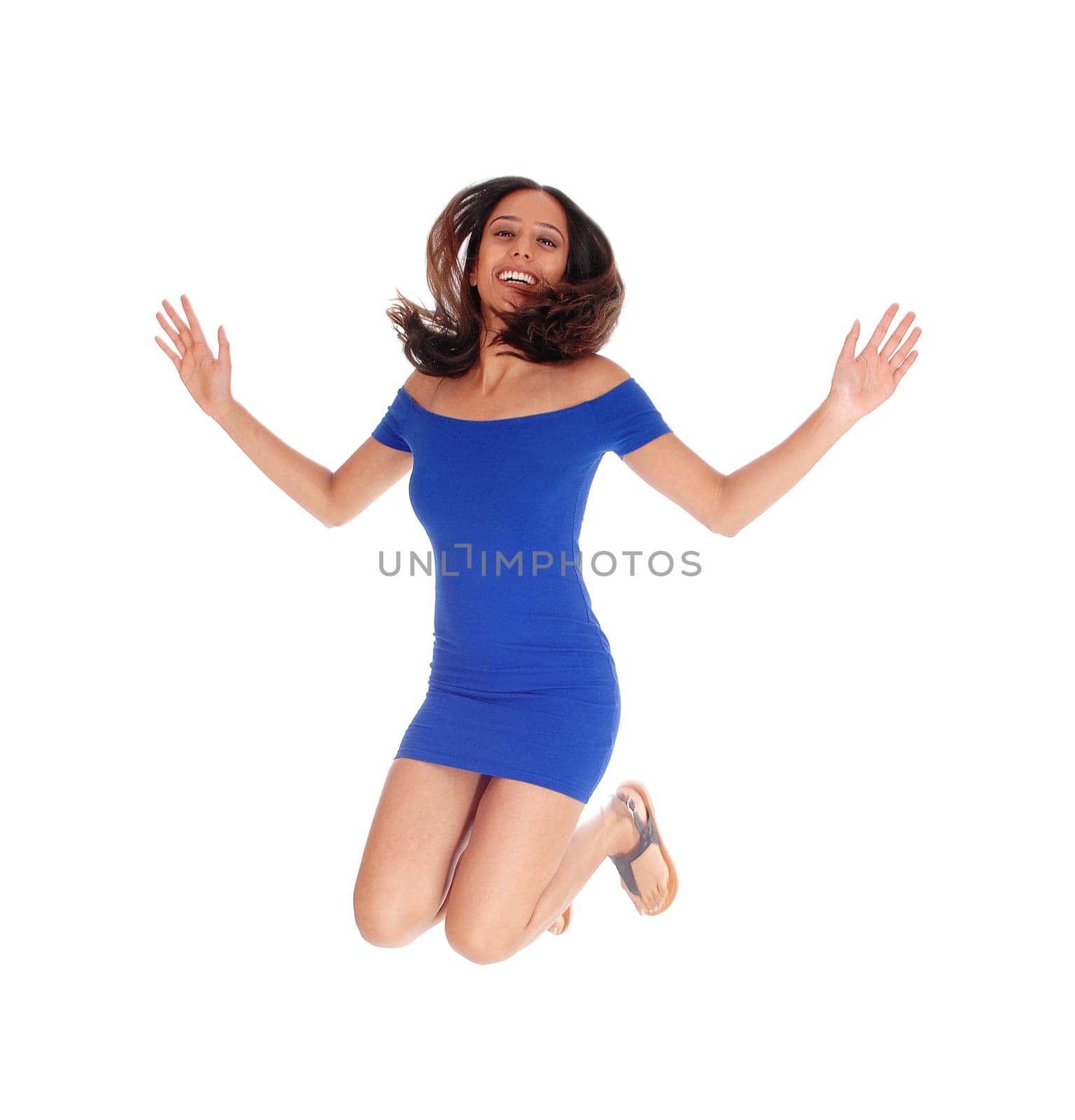 A beautiful young happy woman in a blue dress and brunette hair.jumping into the air, isolated for white background..