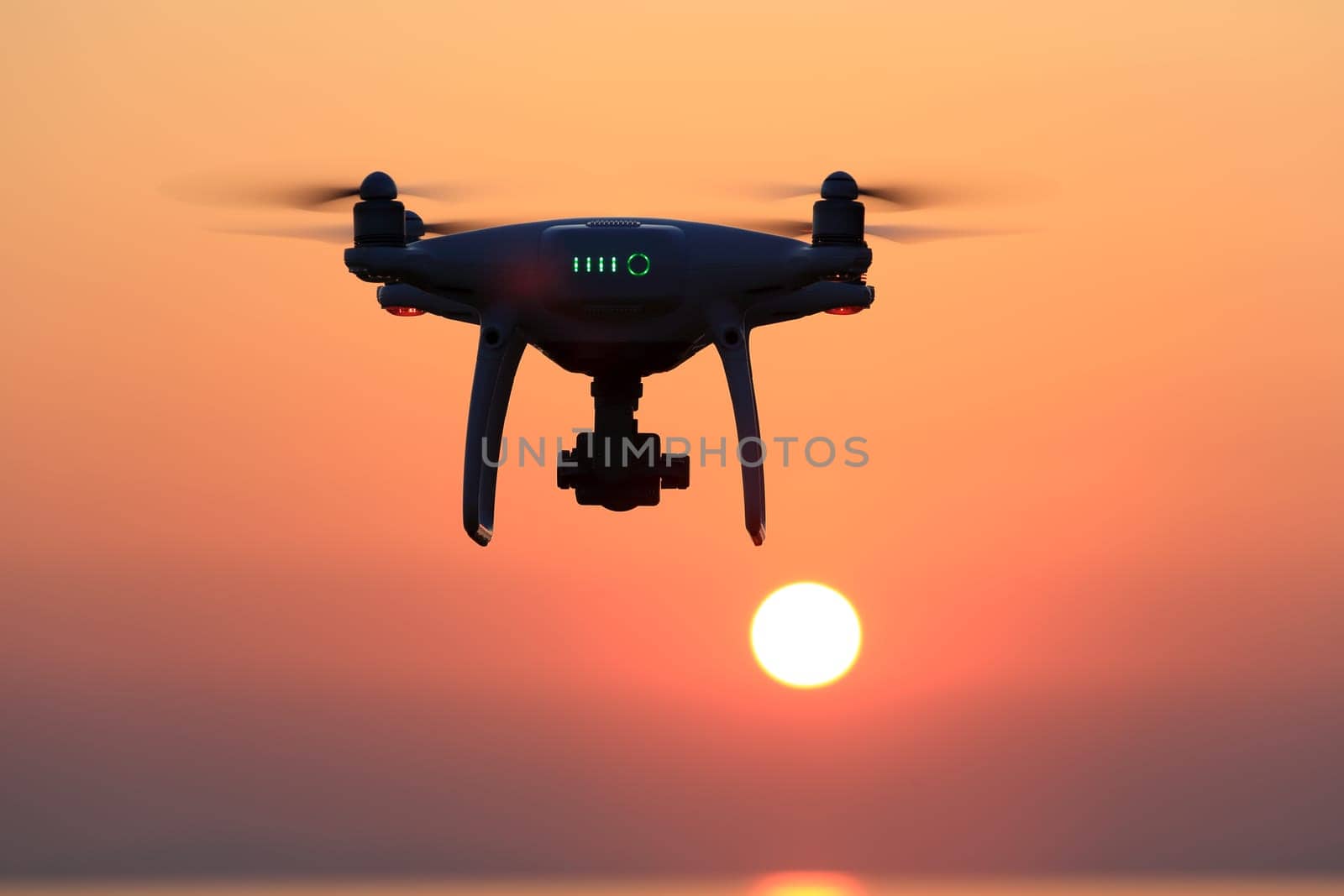 KAGAWA, JAPAN - JUNE 15, 2017: Remote controlled drone Dji Phantom 4 Pro equipped with high resolution video camera flying in air and sunset sky.